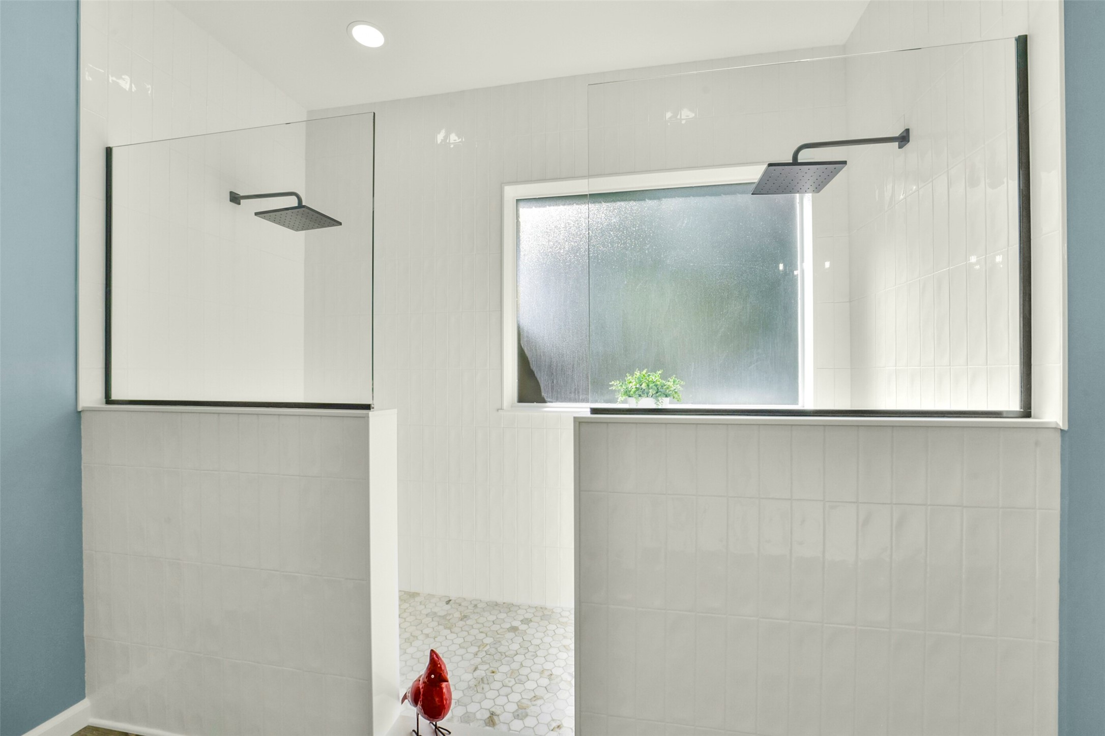 Sleek, modern shower with dual rainfall heads, frosted window, and elegant tilework for a spa-like experience.