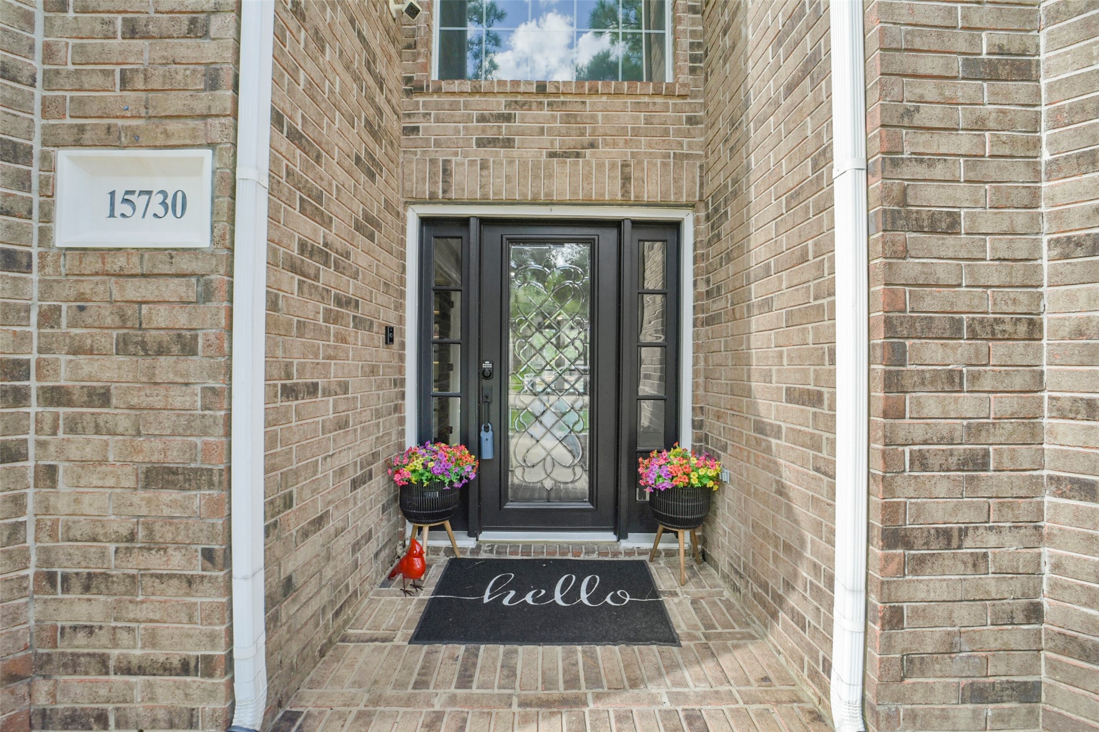 Charming brick entryway featuring a stylish black door with decorative glass panels.