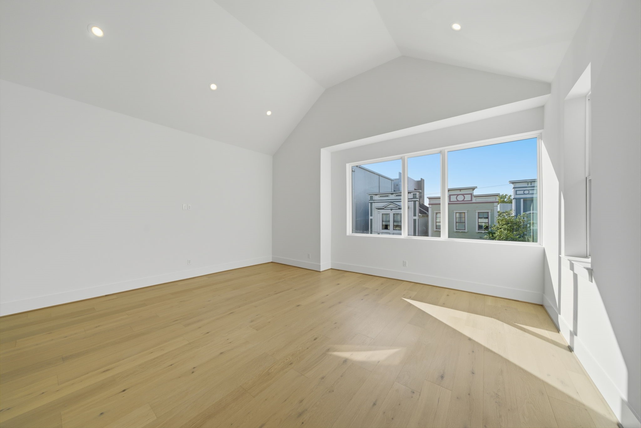 Alternate view of the spacious primary bedroom with beautiful wood flooring. (Photos are of a previously completed home. Finishes are subject to change.)