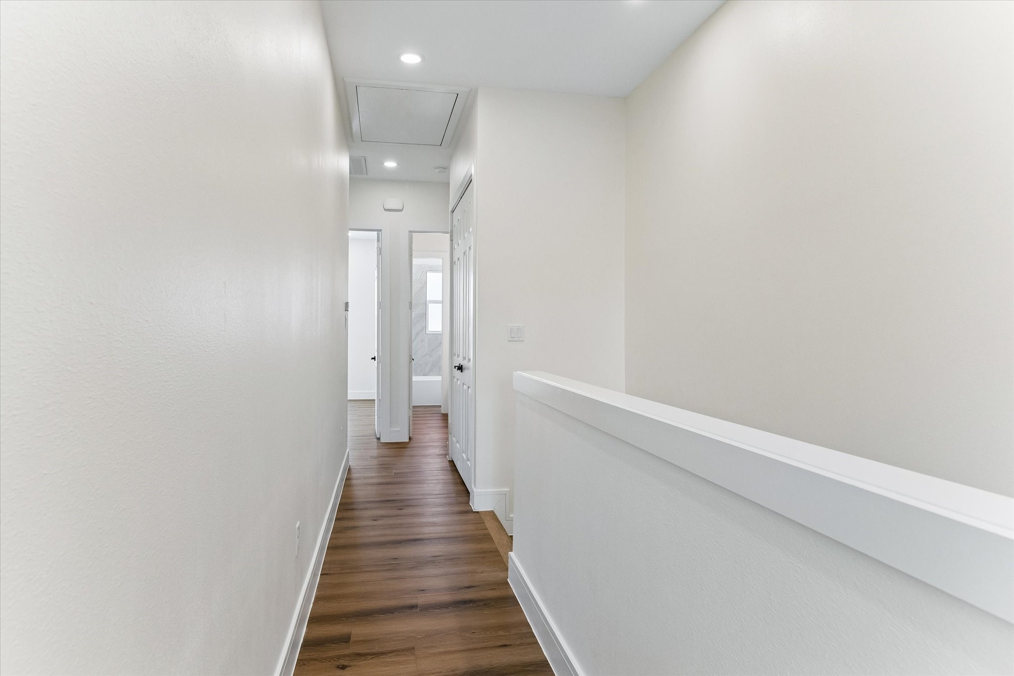 Hallway leading from primary bedroom to guest rooms and upstairs laundry area.