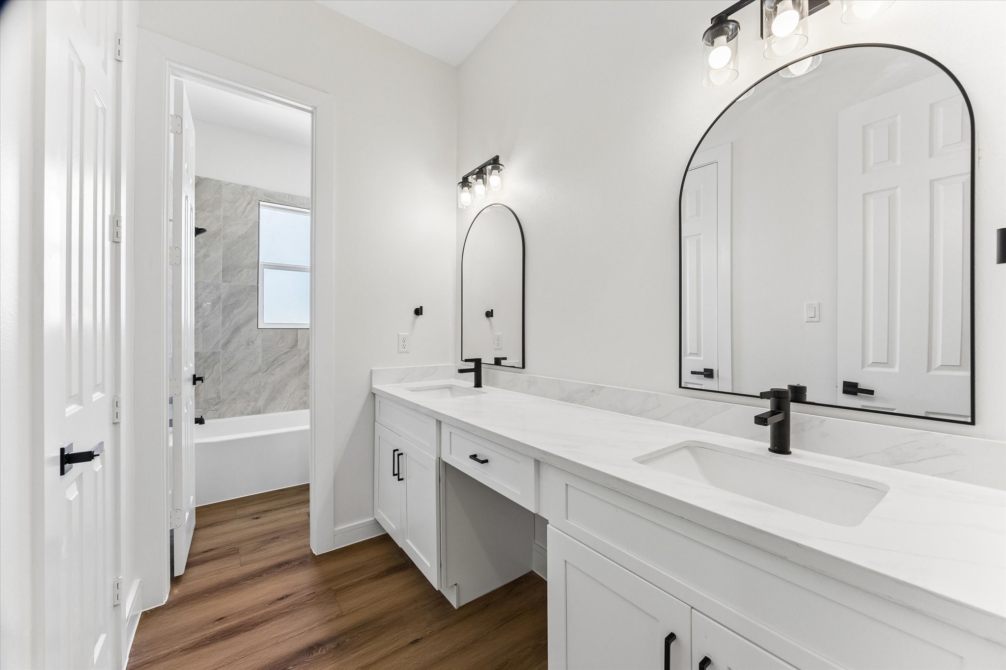 Secondary bathroom with separate area for shower and vanity offering two sinks.