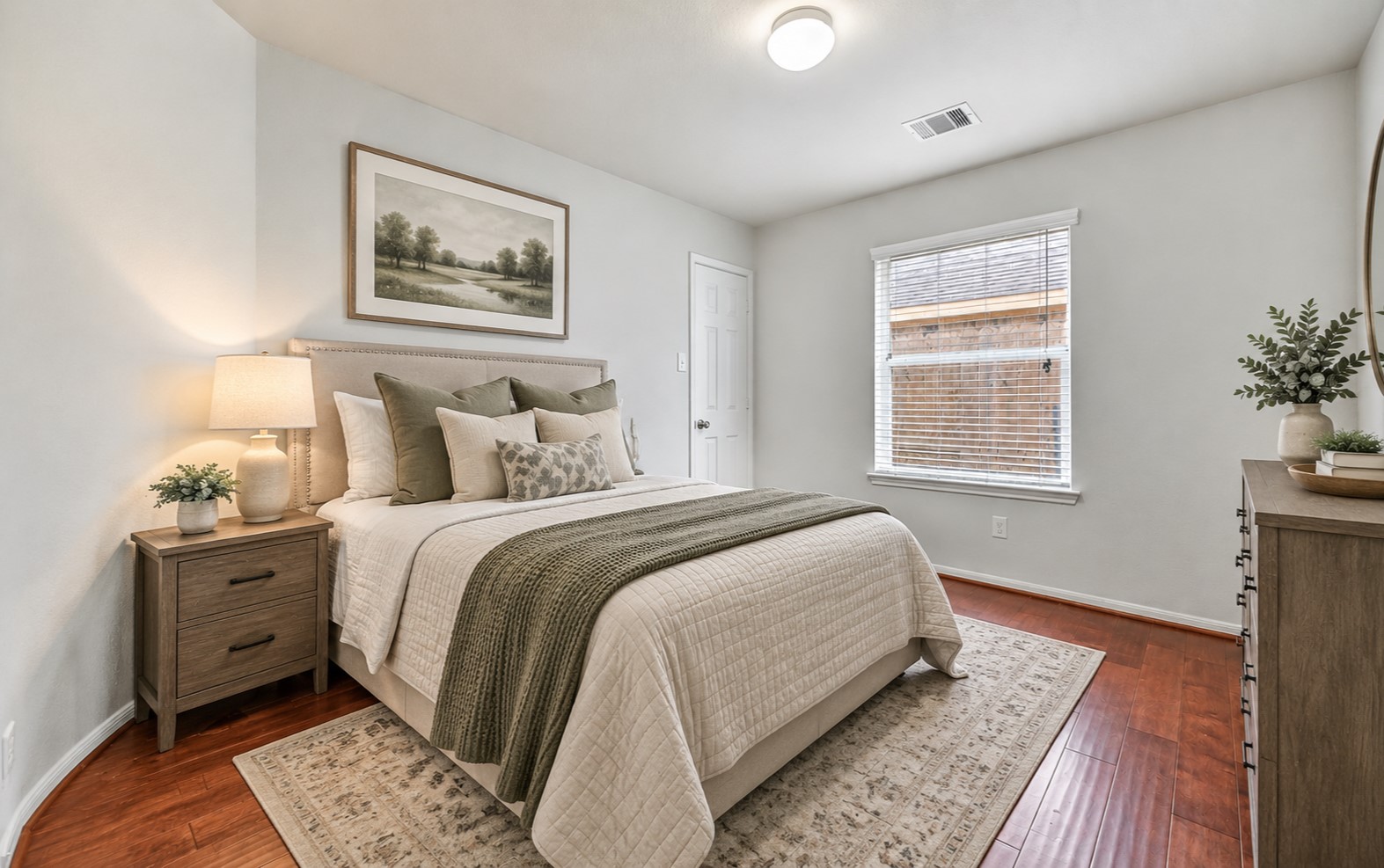 One of three secondary bedrooms offers fresh neutral paint, warm wood flooring, a large window with 2" blinds & a generous walk-in closet, continuing the home's clean, move-in ready feel. (virtually staged)
