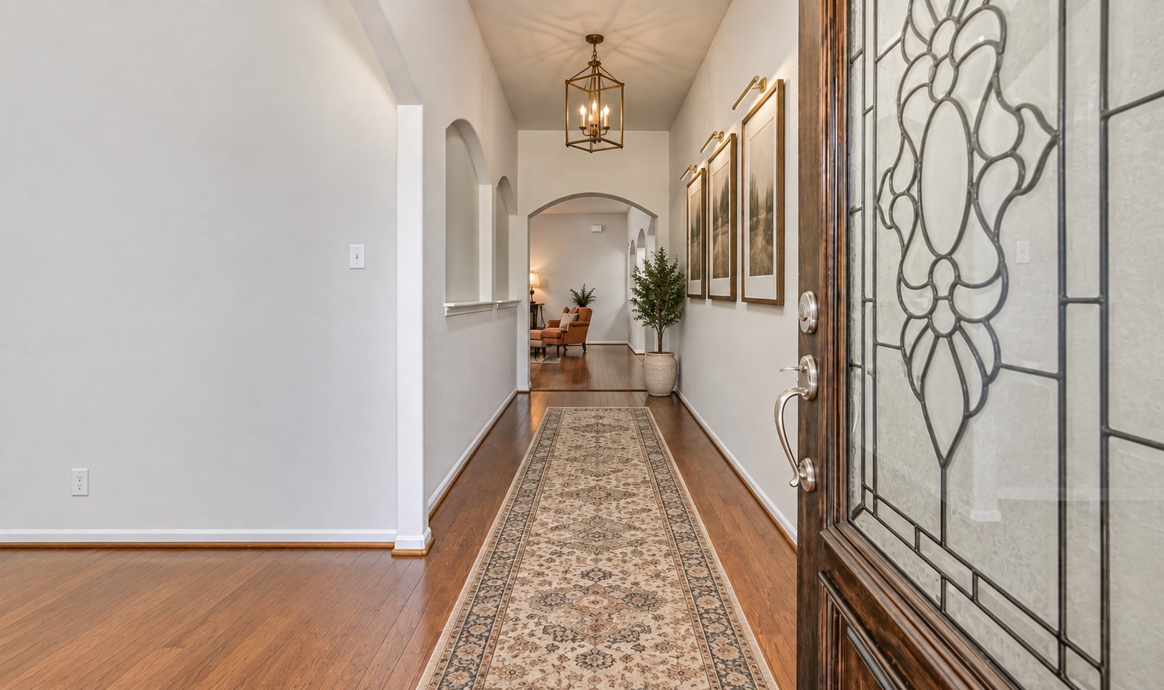 Step inside to a bright, freshly painted interior where warm wood flooring extends through the entry and an impressive series of arched openings introduces the home's open, flowing floor plan.
