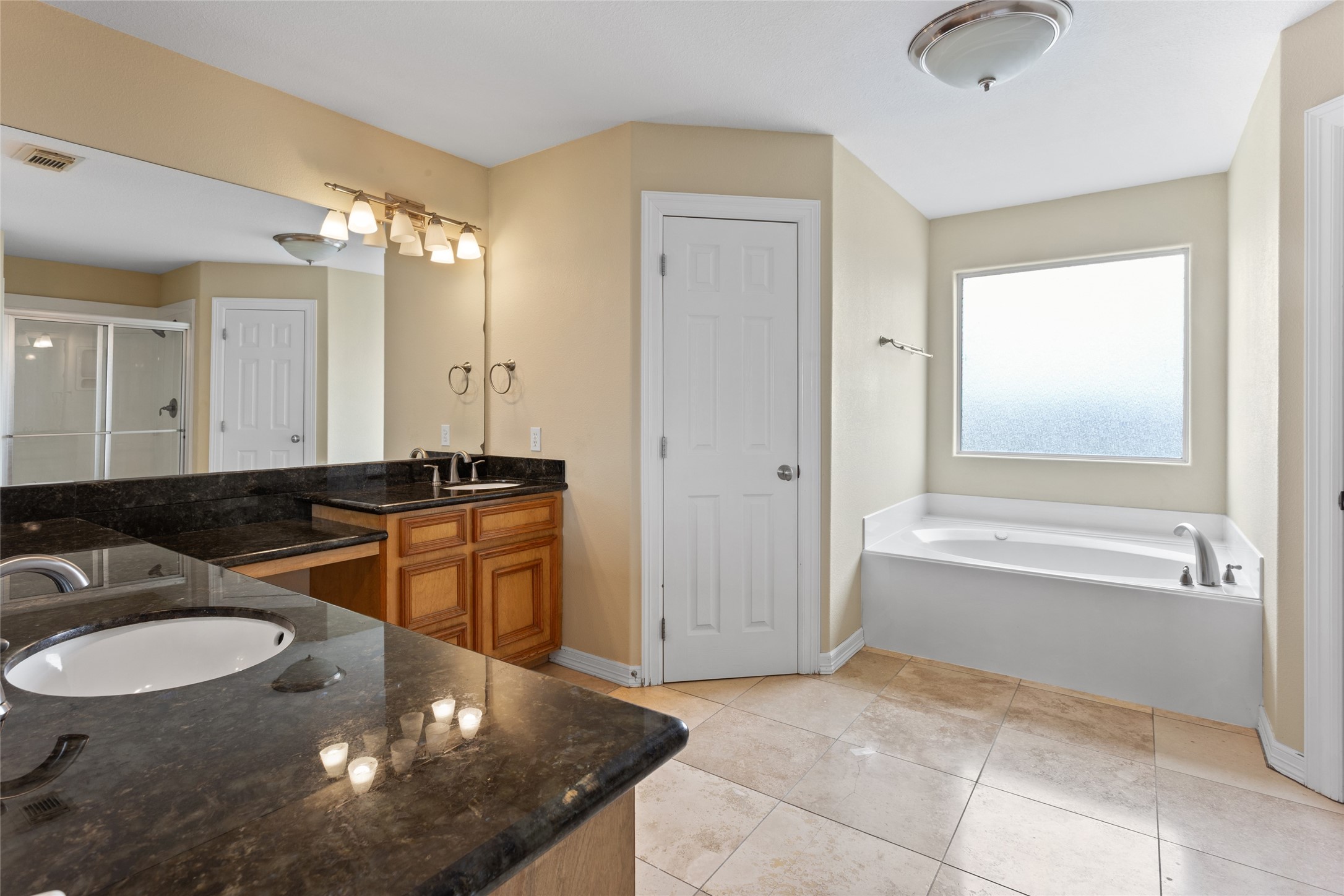 Third floor primary bathroom with double vanities and soaking tub