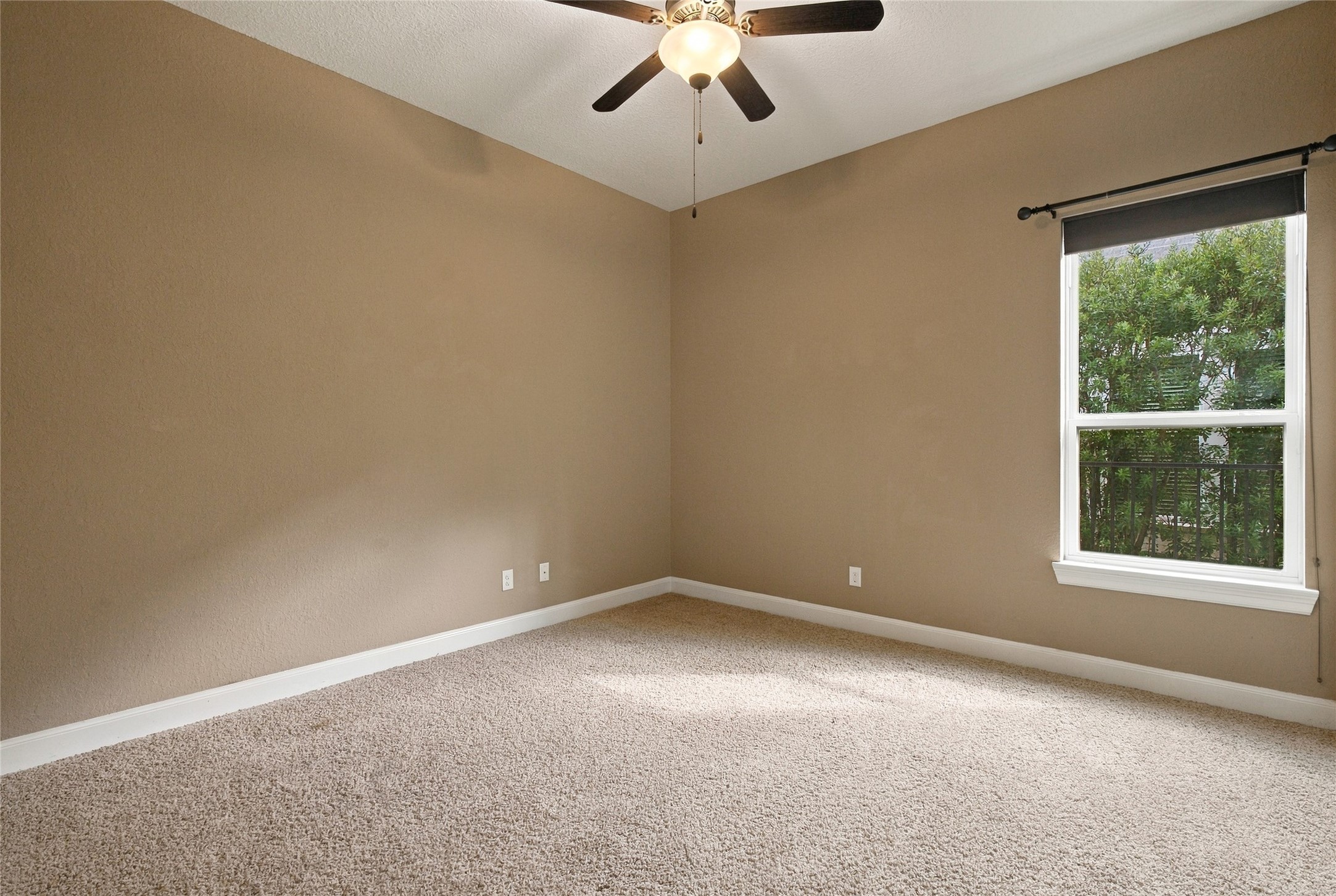 Comfortable secondary bedroom featuring plush carpeting, a window overlooking the outdoors, and a private bathroom.