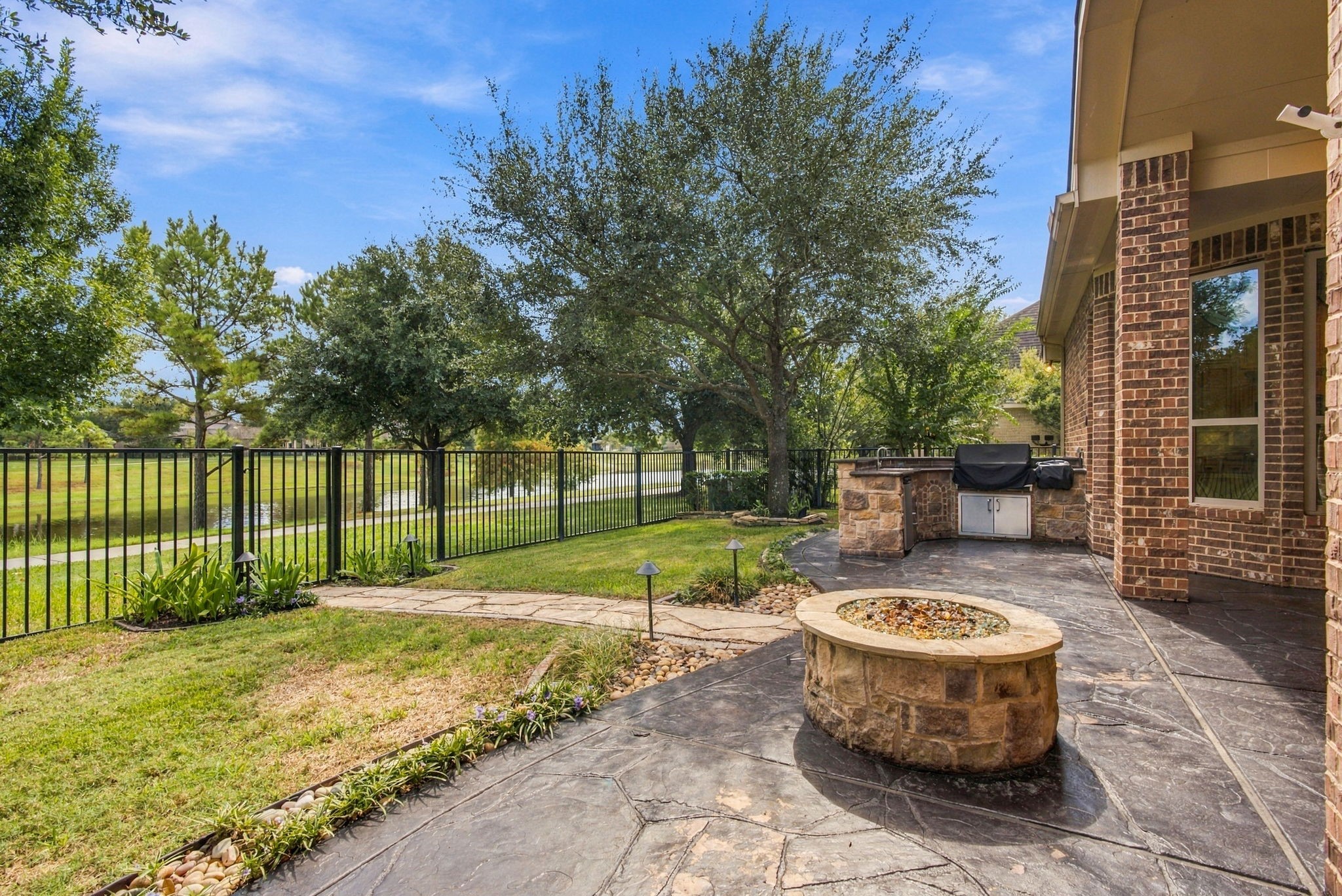 Stone gas fire pit offering the perfect spot to relax while enjoying peaceful water views.