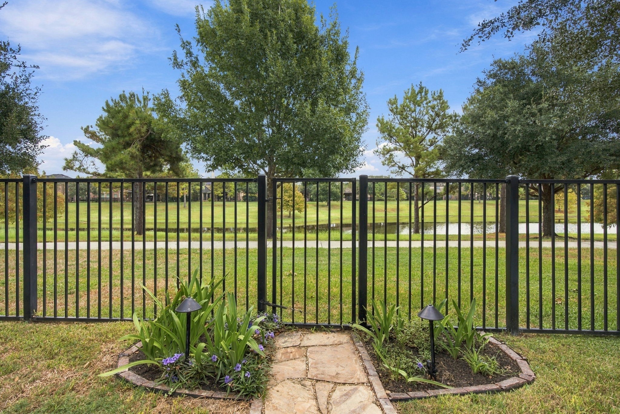 Peaceful water views surrounded by mature trees and lush green space, with a walking trail just beyond the backyard.