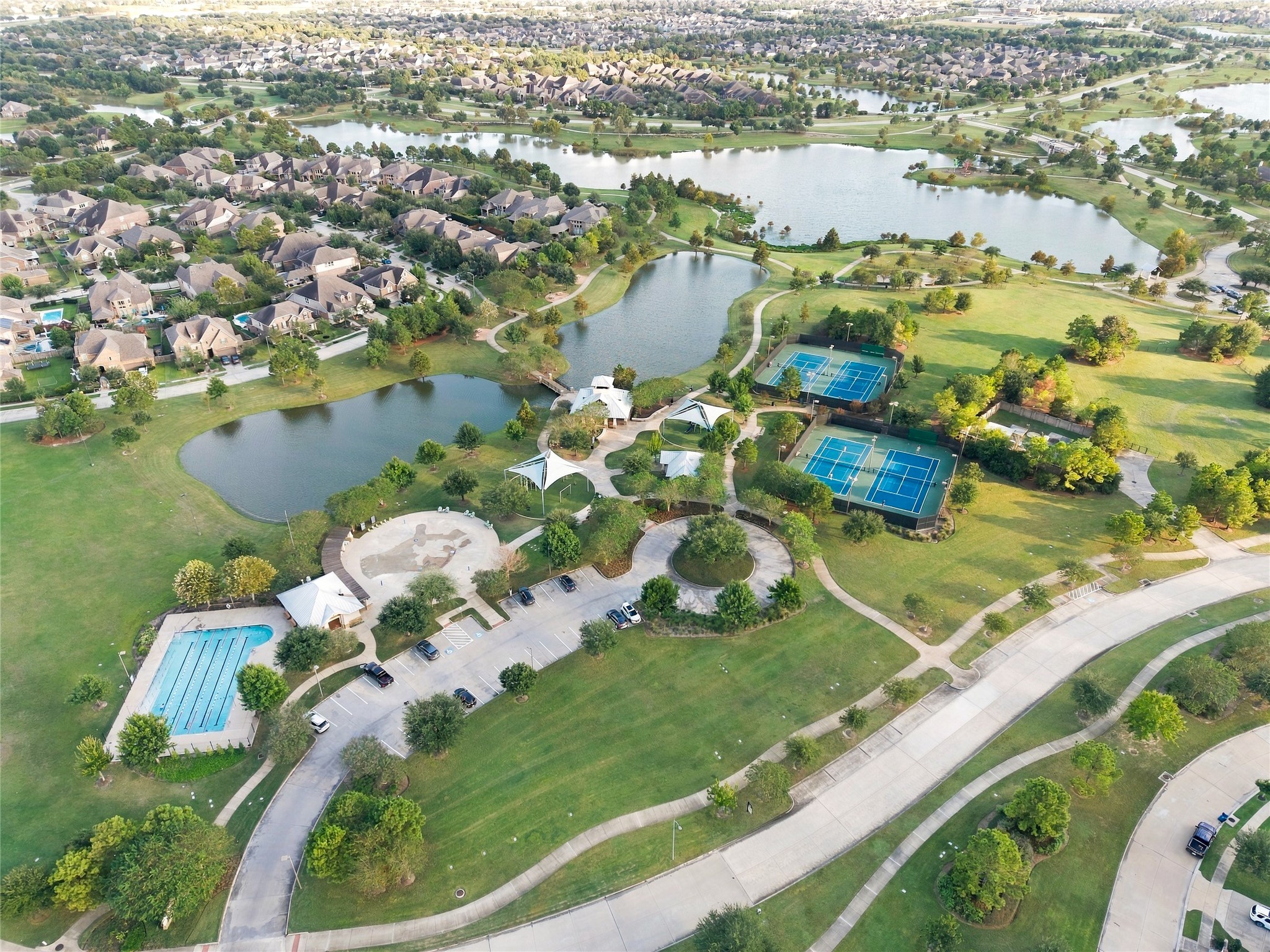 Aerial view highlighting the community's recreational amenities, beautiful green spaces, and picturesque waterfront surroundings.