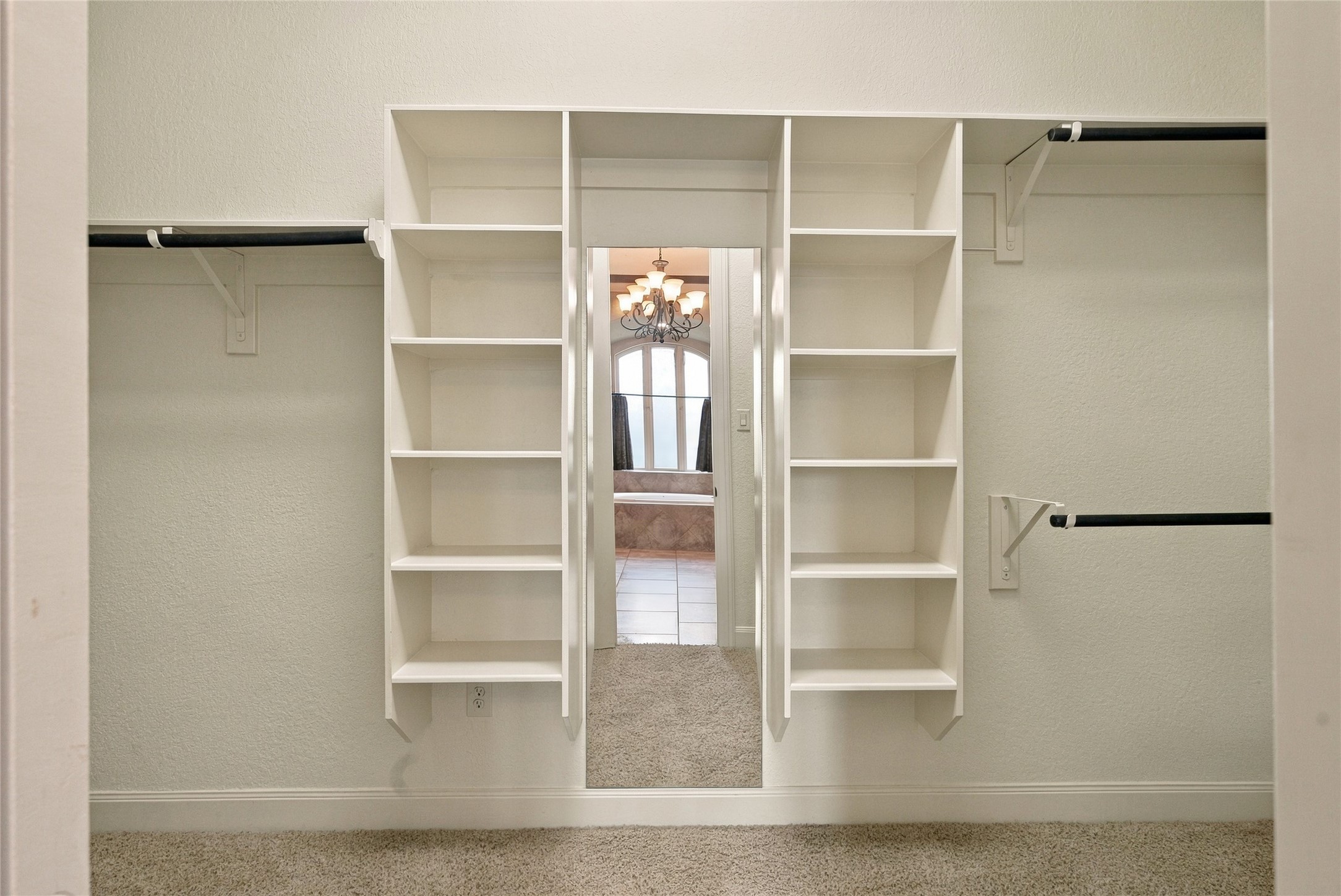 Generous primary walk-in closet featuring built-in shelving and plenty of space for organizing your wardrobe.