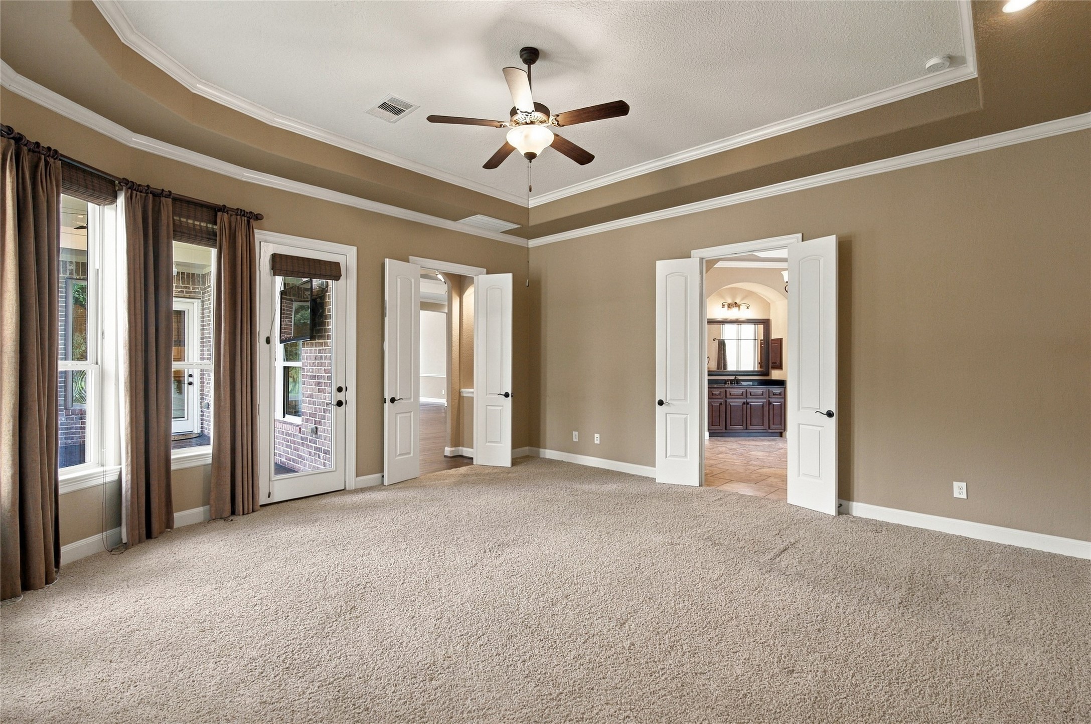 Another view of the inviting primary retreat, offering generous space, abundant natural light, and direct access to the covered patio.