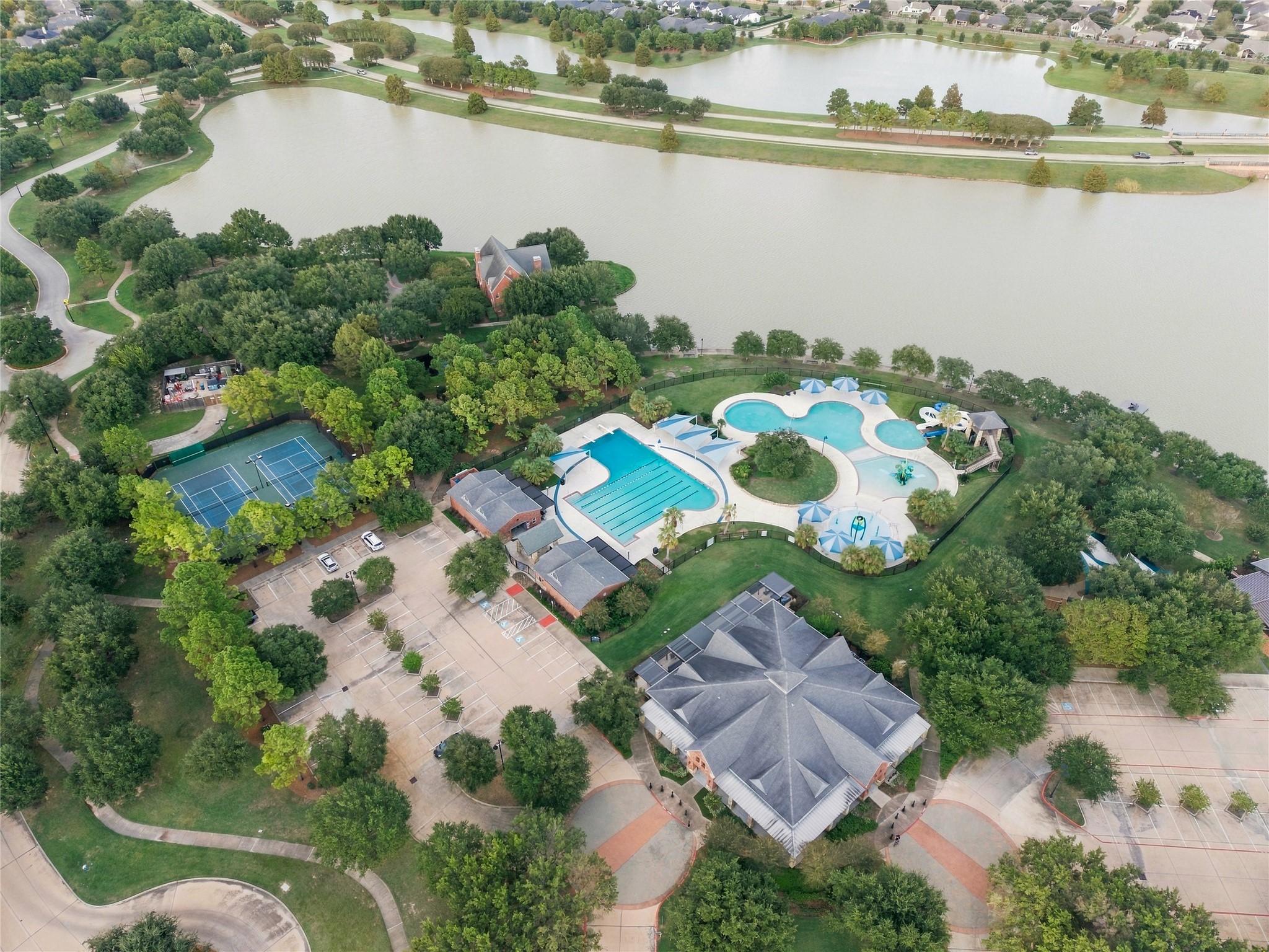 Aerial view highlighting another Bridgeland community center with pools, tennis courts, and a gorgeous lake.