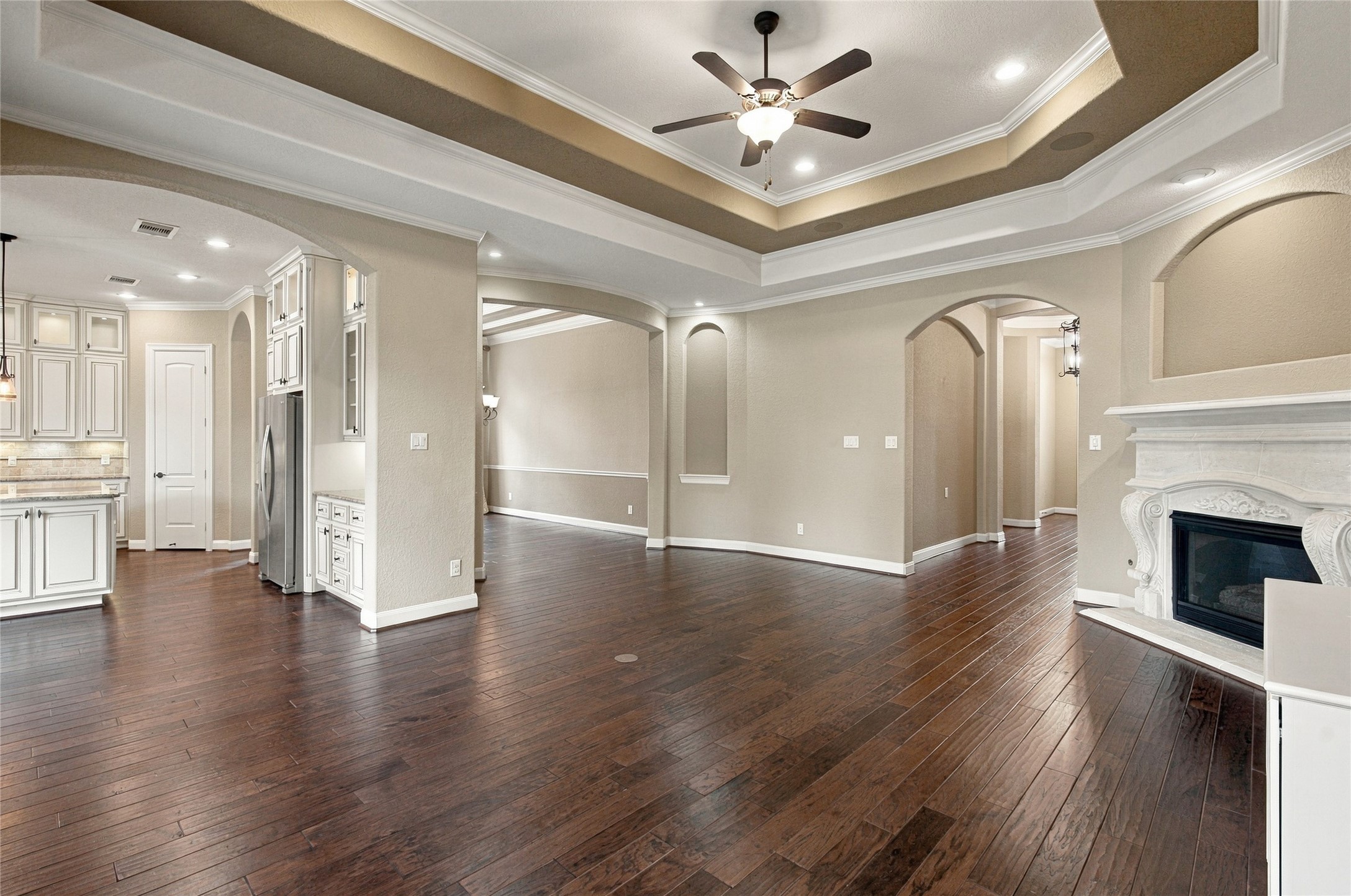 Bright and welcoming living space featuring high ceilings, wood flooring, and easy access to the kitchen and dining areas.