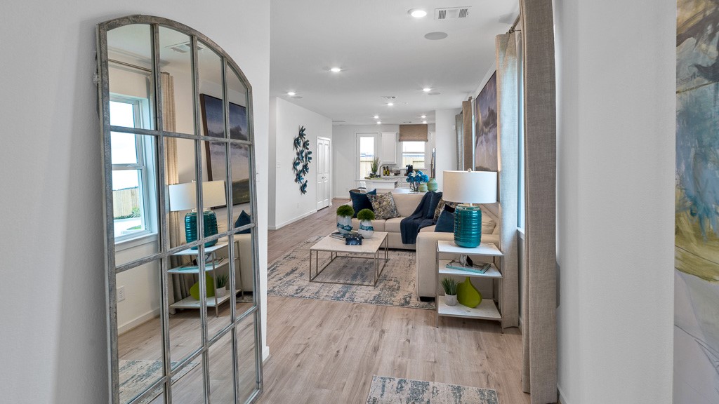 Gorgeous open plan has sightlines to back of home, beautiful wood floors, and designer white walls lend to the inviting ambiance.