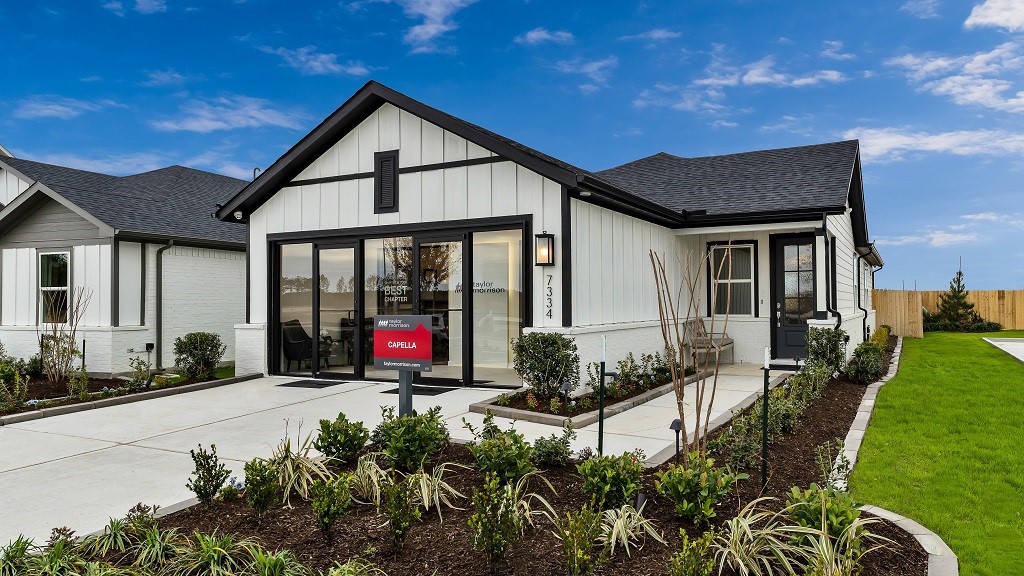Modern facade is perfection with thoughtfully selected designer colors and materials, and the result is stand out home! Modern wall lantern highlights the floating address numbers and walkway to front entry. Landscaped beds add softness and vibrant color.