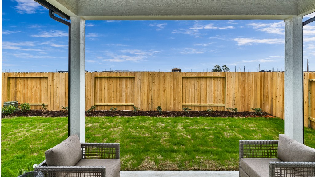Gorgeous backyard has a good-neighbor fence with landscaped bed and covered lanai.