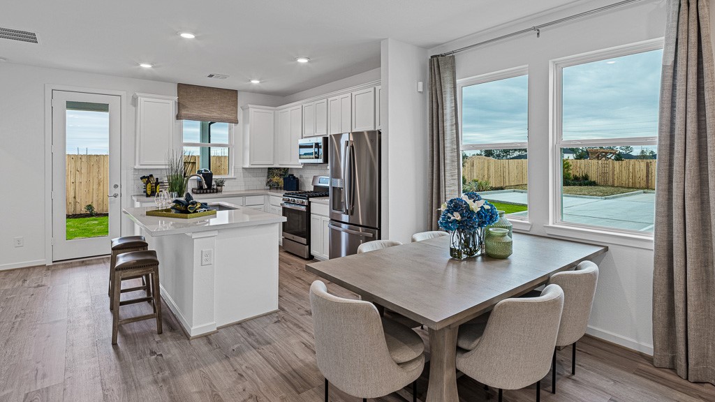 Dining and kitchen are open, light, and airy with designer color palette and finishes creating an appealing ambiance.
