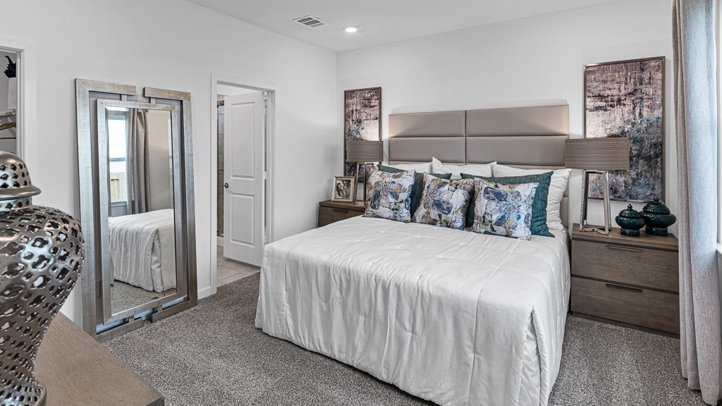 Primary suite has an inviting presence with understated sophistication by designer white walls, and beautiful warm gray premium carpeting.