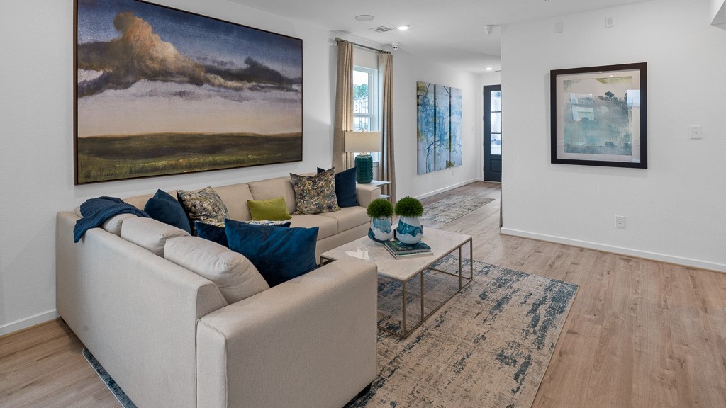 Designer white walls with wood flooring adding warm color, character and texture make this interior feel light, bright, upscale, and inviting.