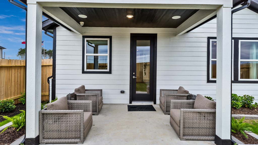 Black slatted ceiling with recessed lighting and black full lite glass door add high end style to this home.