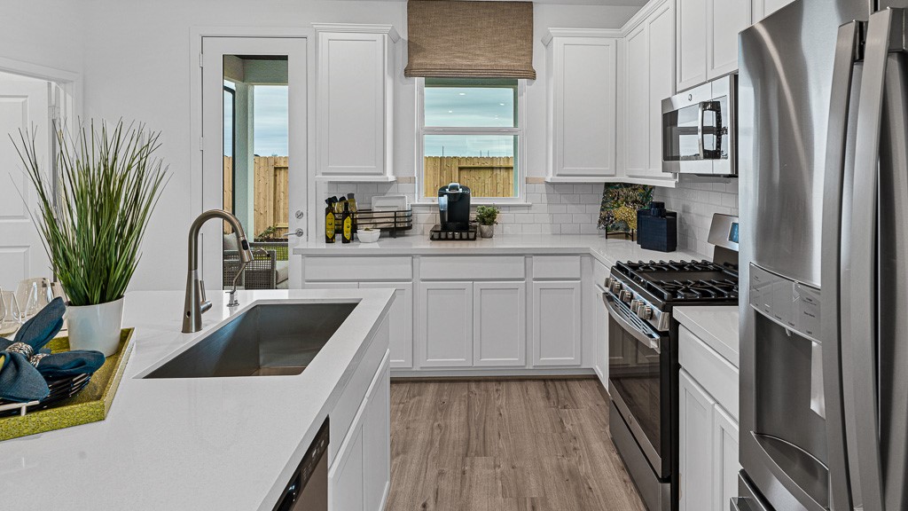 Modern kitchen is gorgeous with natural lighting, and well laid out for convenience, efficient use of space, all while being surrounded in simplistic beauty.