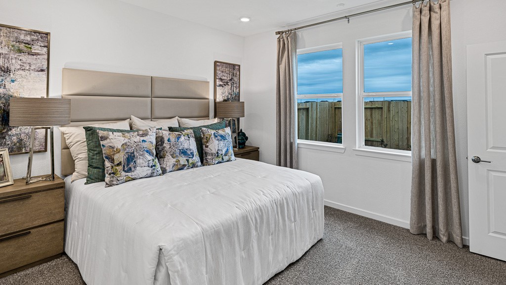 Primary suite has beautiful windows with views of backyard and elegant custom drapery.
