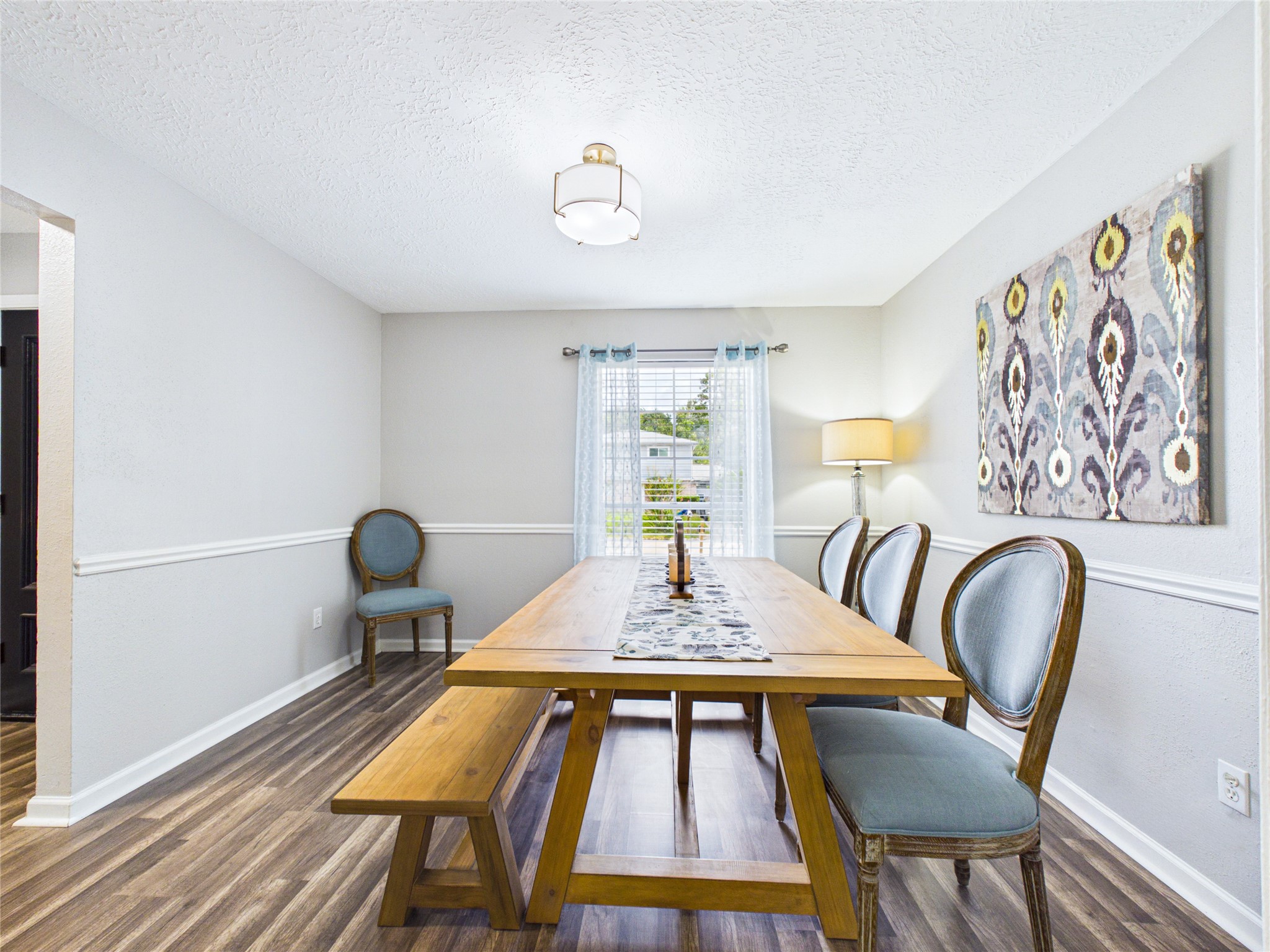 Charming dining area with elegant wood flooring with plenty of light.