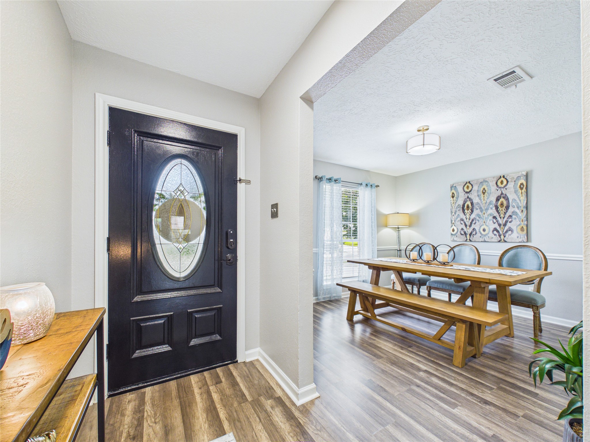 Inviting entryway with a stylish black door and near dining area.