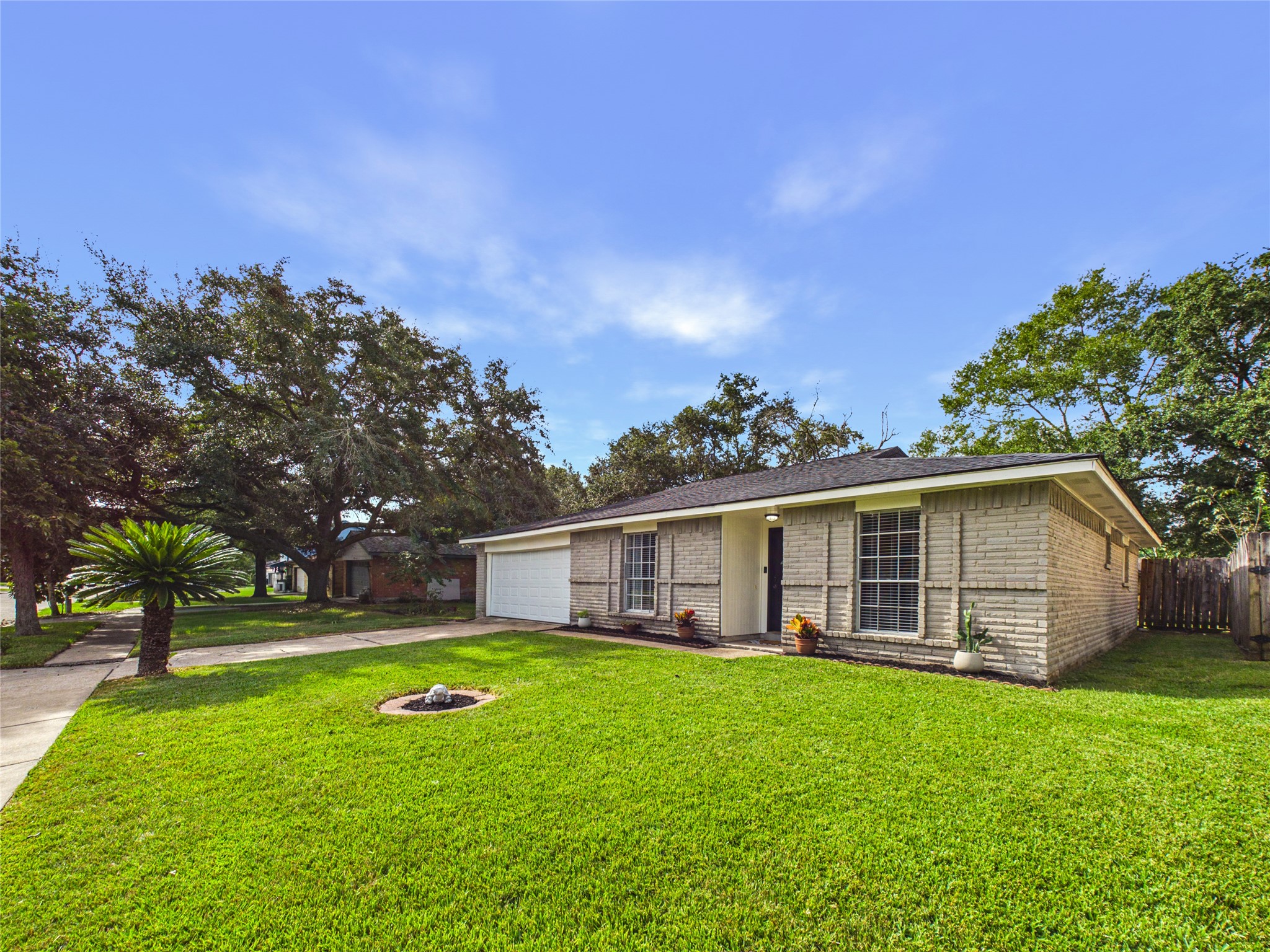 Charming single-story home with a welcoming facade, featuring a spacious two-car garage and a well-maintained.