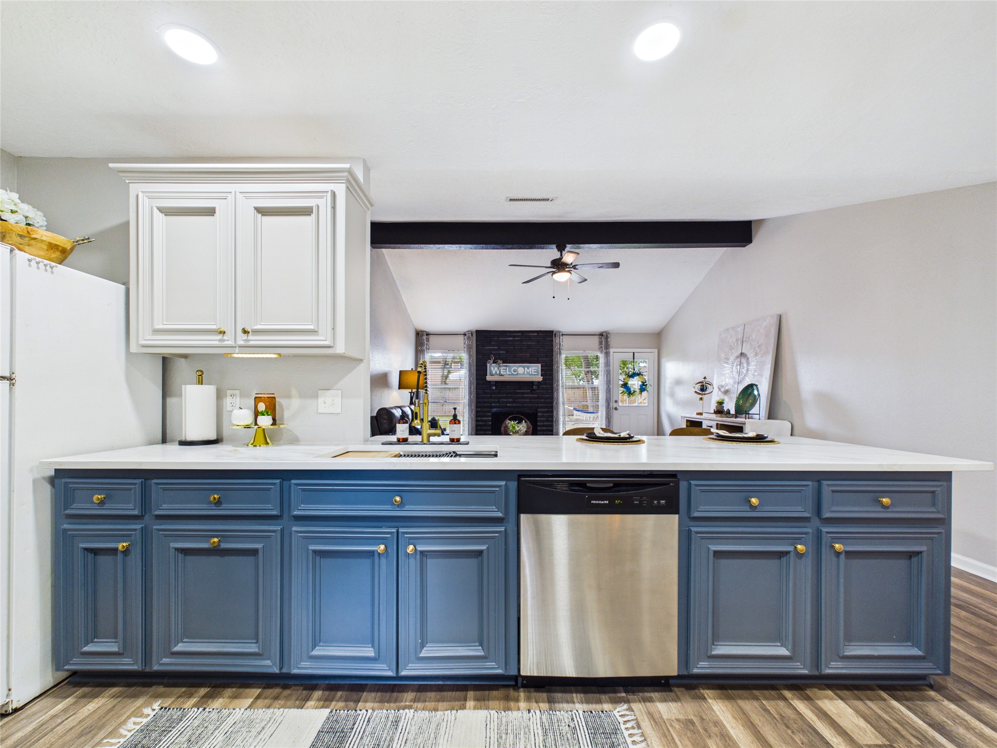 New farmhouse sink goes well with the new quartz counter tops. In the cabinet to the below and to the left of the sink sits hideaway trash cans.