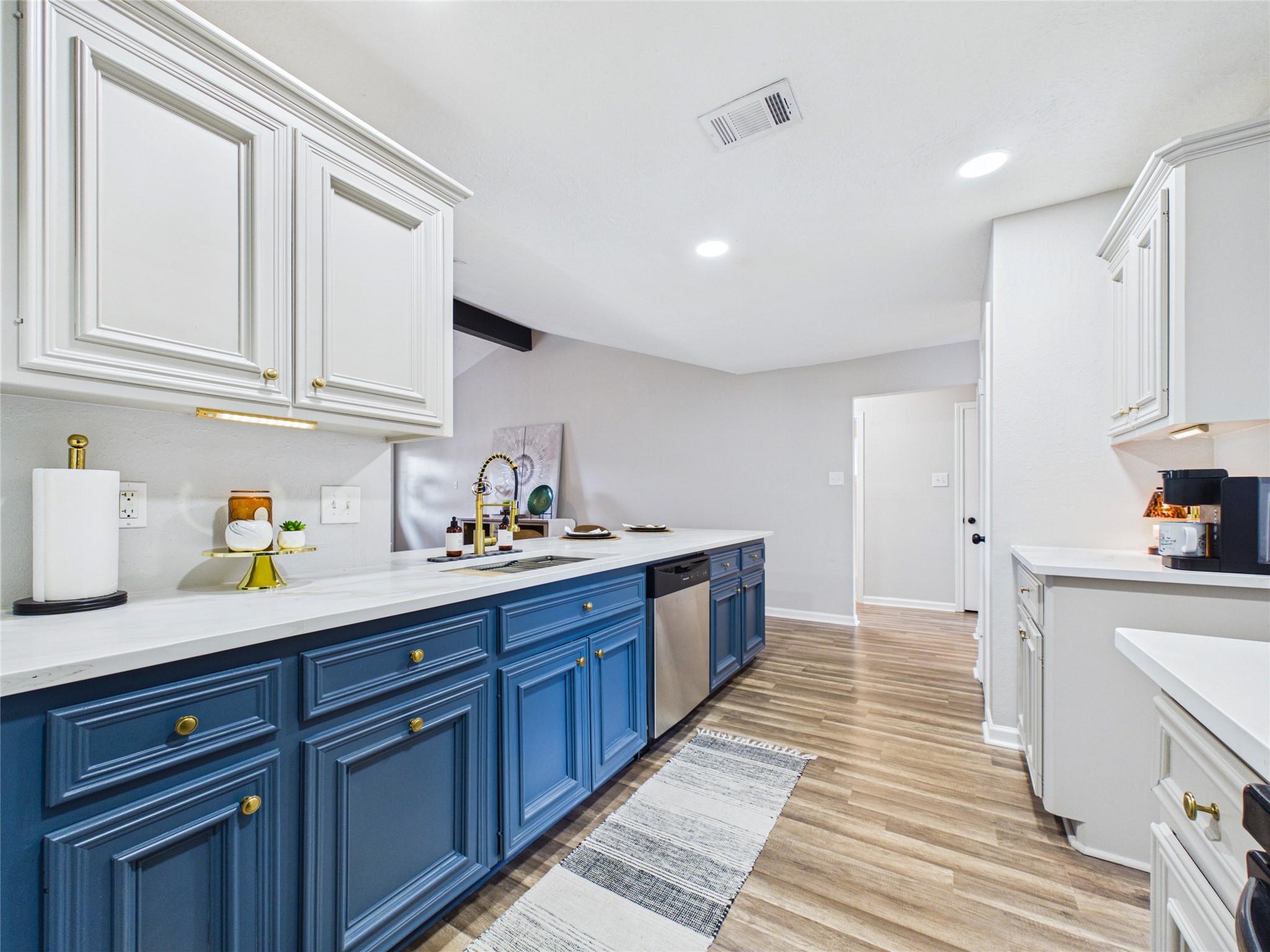 Bright and spacious kitchen featuring elegant blue lower cabinets, sleek white quartz countertops, and stainless steel appliances. Bright and spacious kitchen featuring elegant blue lower cabinets, sleek white quartz countertops, and stainless steel appliances.