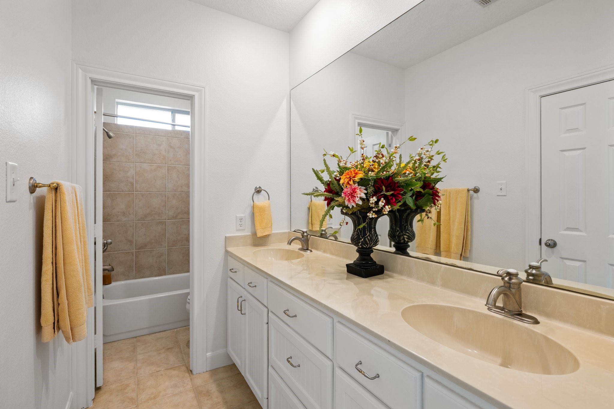 Generous ensuite bath enhances the secondary bedroom. Complete with double sinks, plenty of counters space and cabinets for storage.
