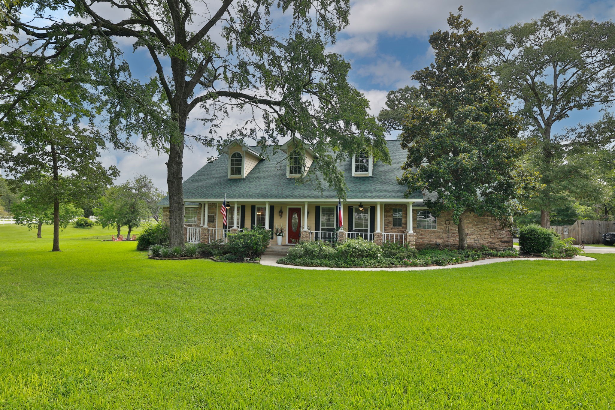 Charming two-story home with a classic front porch, nestled among mature trees and lush green lawn. Perfect for peaceful living with ample outdoor space. Charming two-story home with a classic front porch, nestled among mature trees and lush green lawn. Perfect for peaceful living with ample outdoor space.
