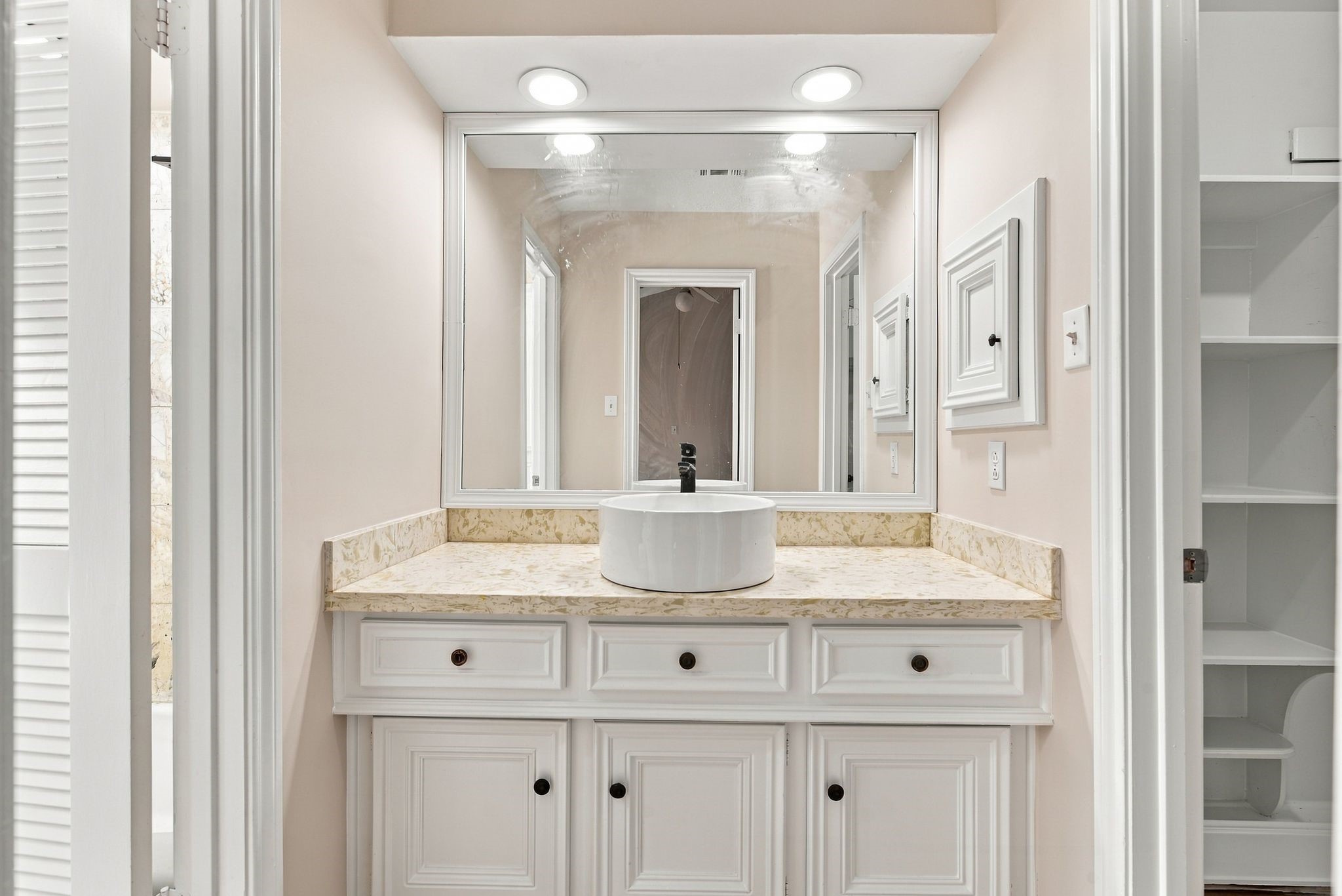 Primary ensuite bathroom featuring a double-sink vanity, generous countertop space, and built-in storage.