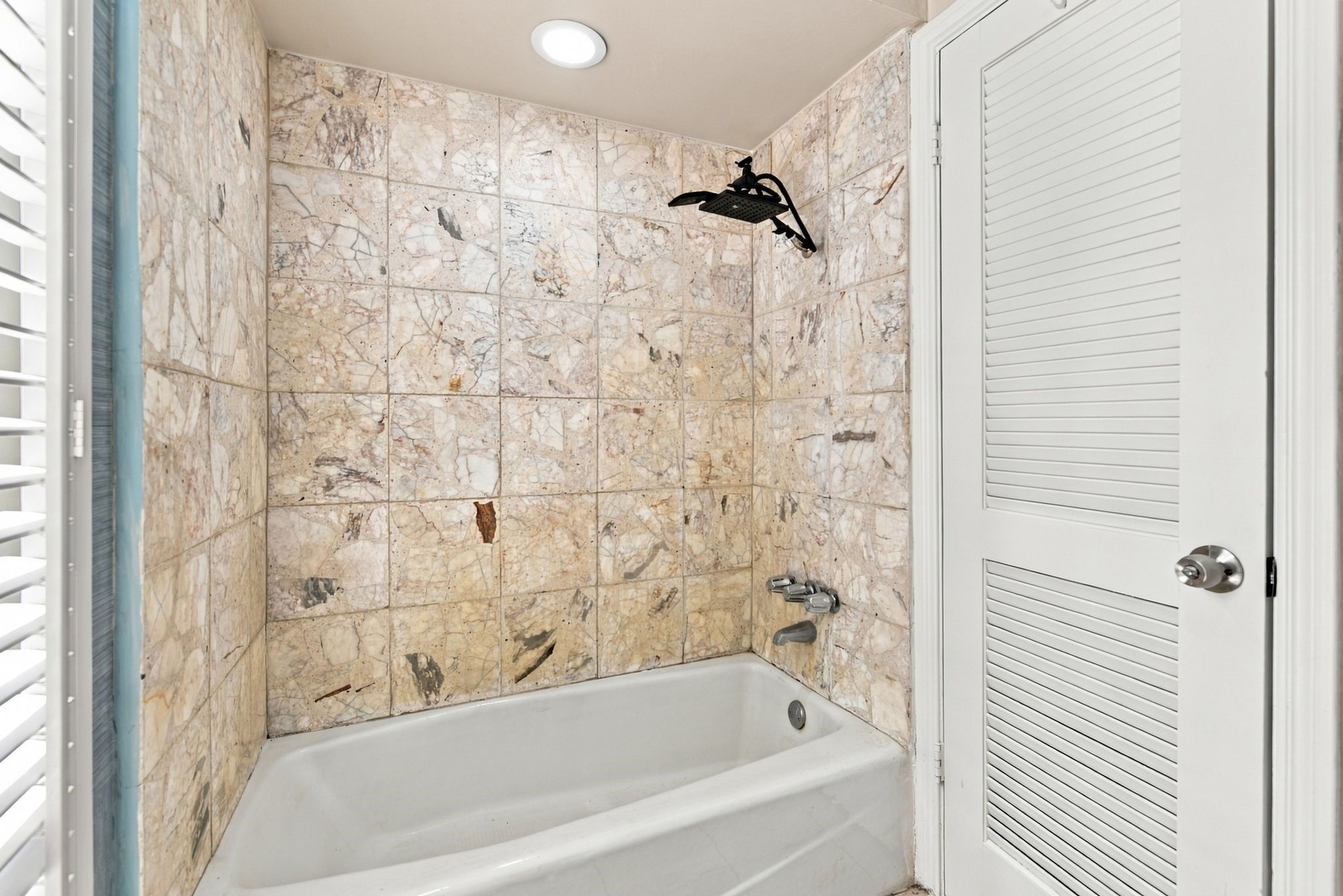 Primary bathroom featuring a separate bathing area with a tub and shower combination.