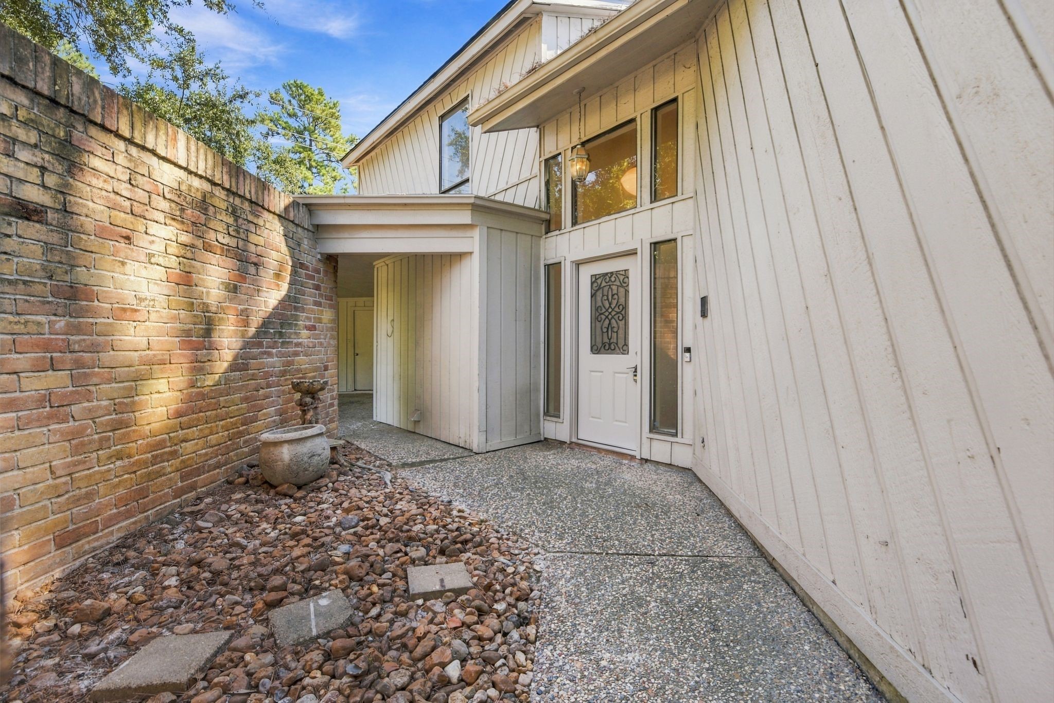 Private front courtyard featuring gated access to both the carport and the home's main entrance, offering a welcoming transition into the property.