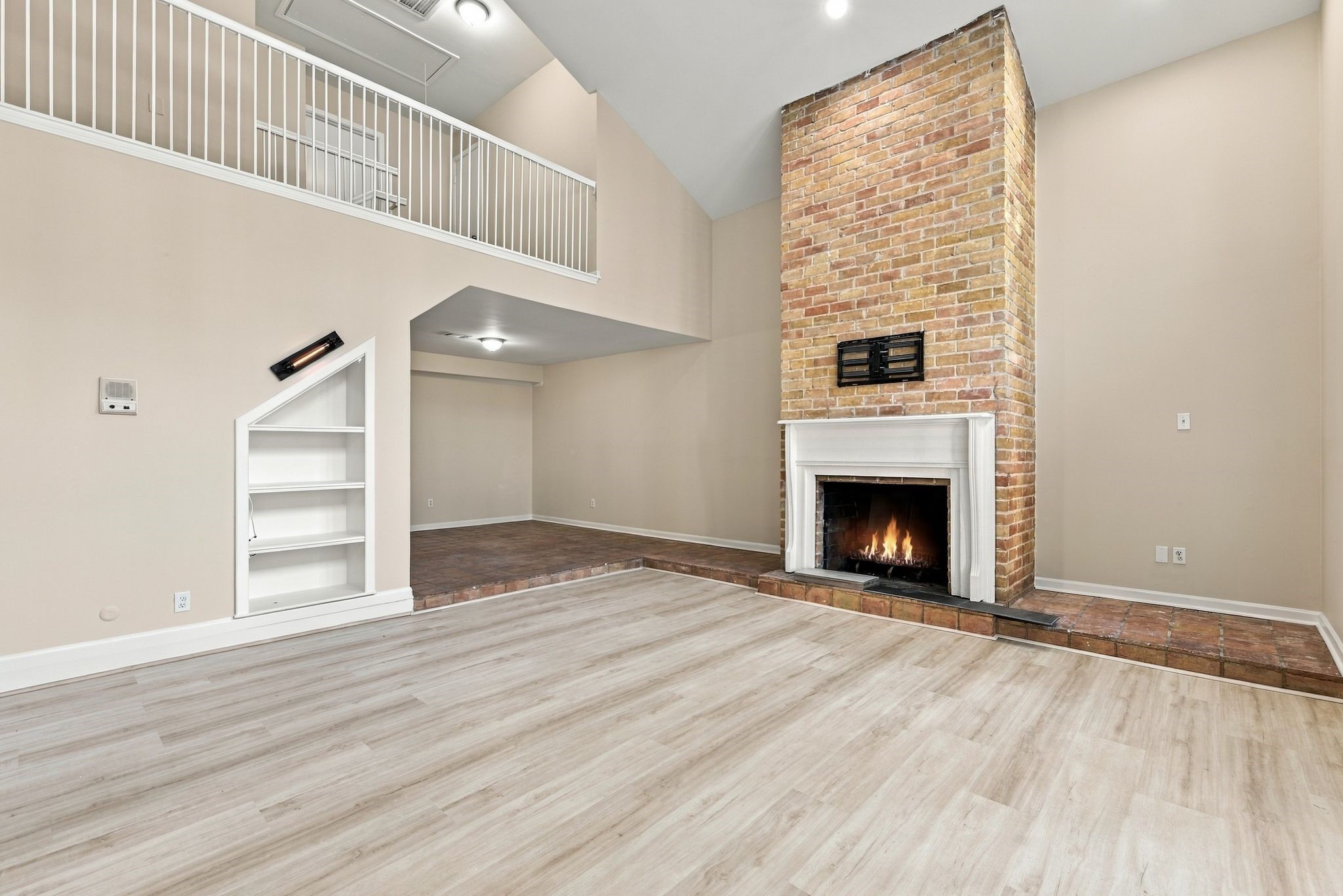 Floor-to-ceiling brick fireplace anchors this impressive living space with vaulted ceilings and an open layout. Floor-to-ceiling brick fireplace anchors this impressive living space with vaulted ceilings and an open layout.