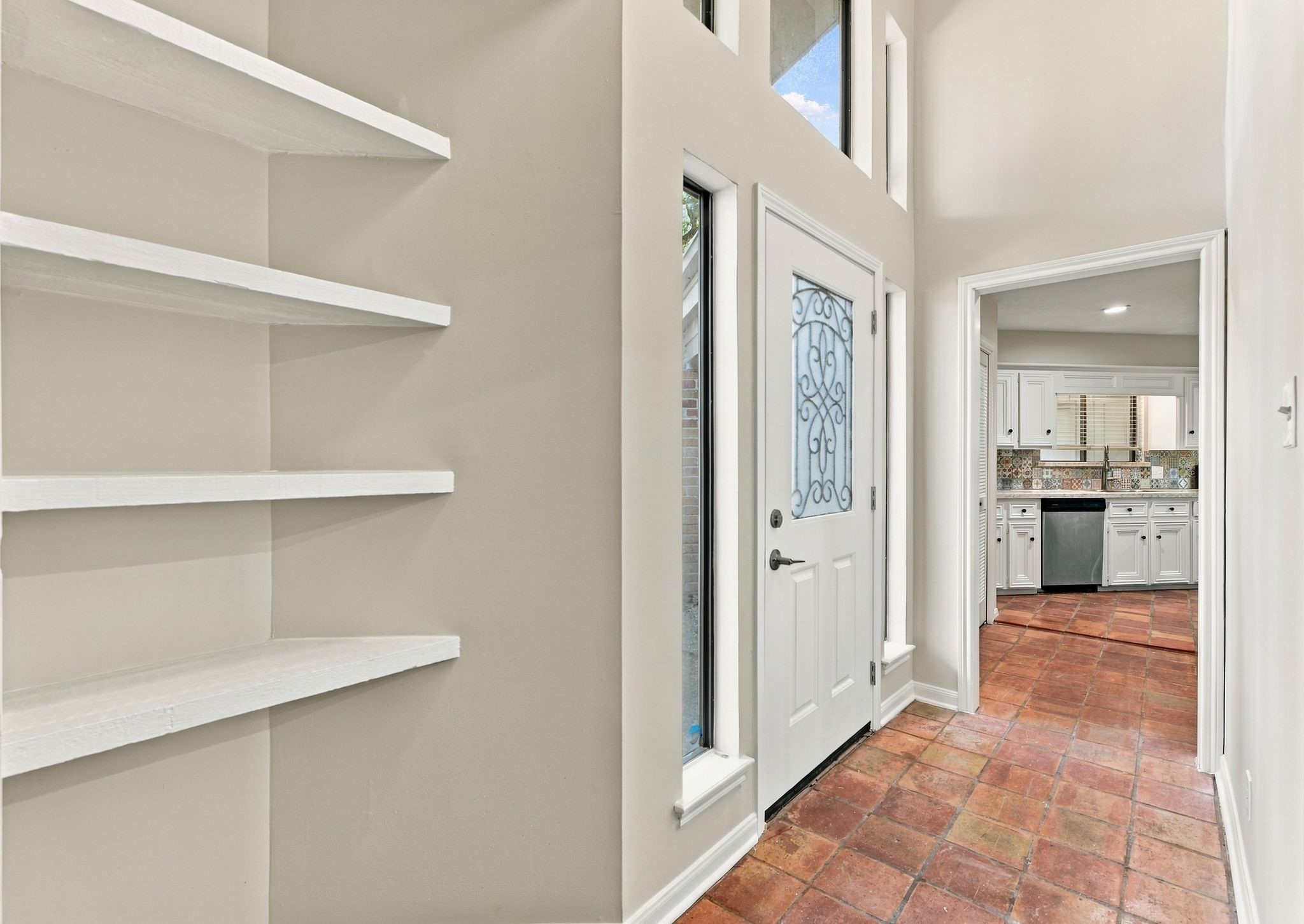 Welcoming entryway with built-in shelving and a view into the home's spacious living areas. Welcoming entryway with built-in shelving and a view into the home's spacious living areas.