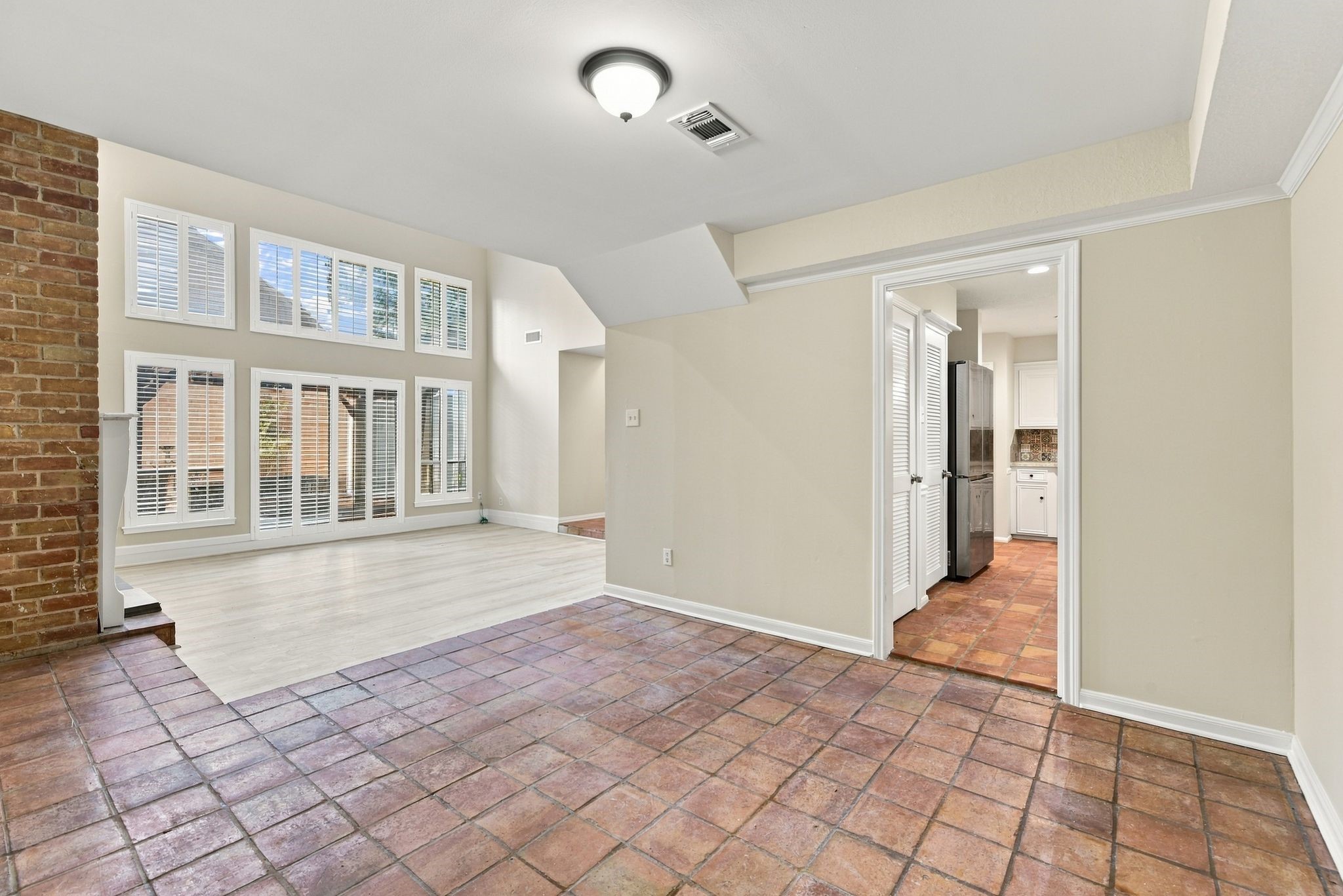 Formal dining room featuring Saltillo tile flooring, natural light, and an open connection to the living area.