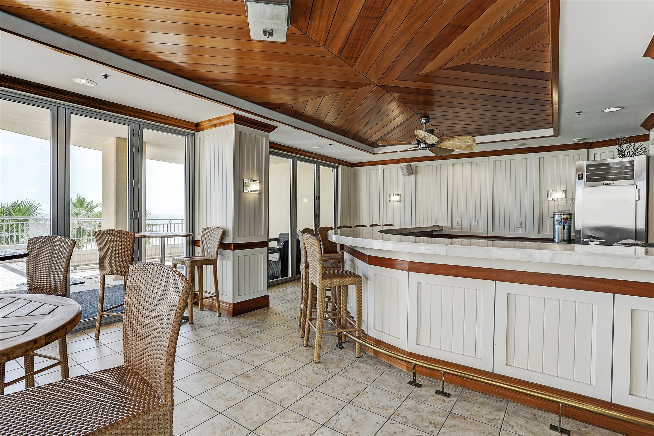 Palisade Palms Lanai Bar overlooks the pool deck and Gulf, with indoor and outdoor seating for relaxing or gathering with friends.