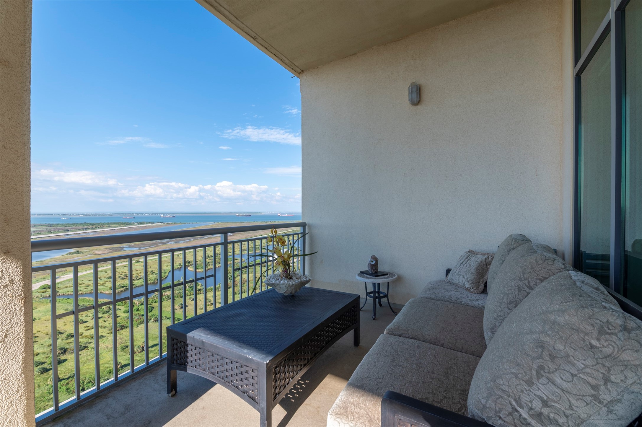 Private balcony off the bay-view primary suite offers a comfortable outdoor seating area high above the island.