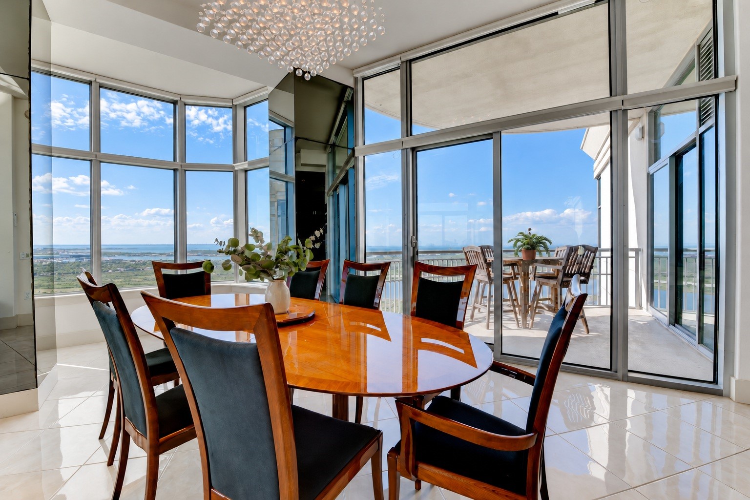 Custom-made Italian dining table anchors the spacious dining area, with direct balcony access and water views beyond. Custom-made Italian dining table anchors the spacious dining area, with direct balcony access and water views beyond.