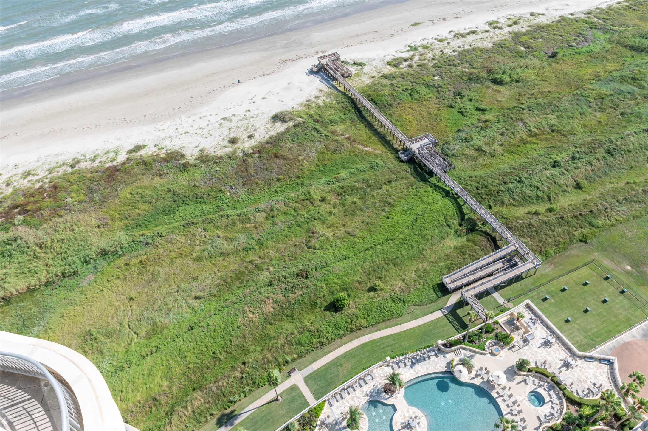 From the 28th floor, the view looks straight down to Palisade Palms pool deck, private beach access and the Gulf beyond.
