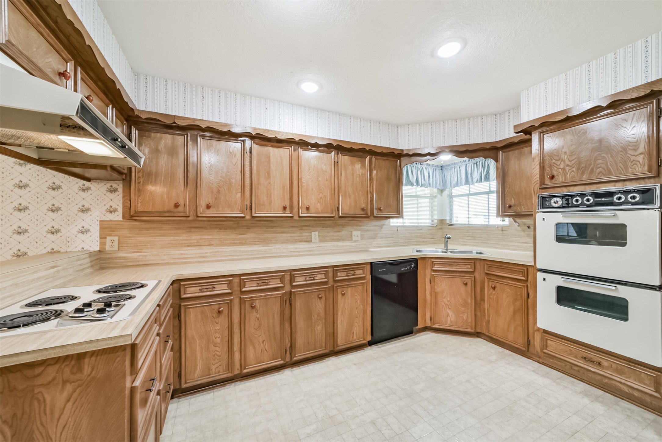 Enjoy abundant cabinet space and timeless craftsmanship in this kitchen. Originally built in 1980, the handcrafted cabinetry reflects the quality and attention to detail of its era. The butcher-block-style countertops add warmth and versatility, complementing a variety of decorating styles.