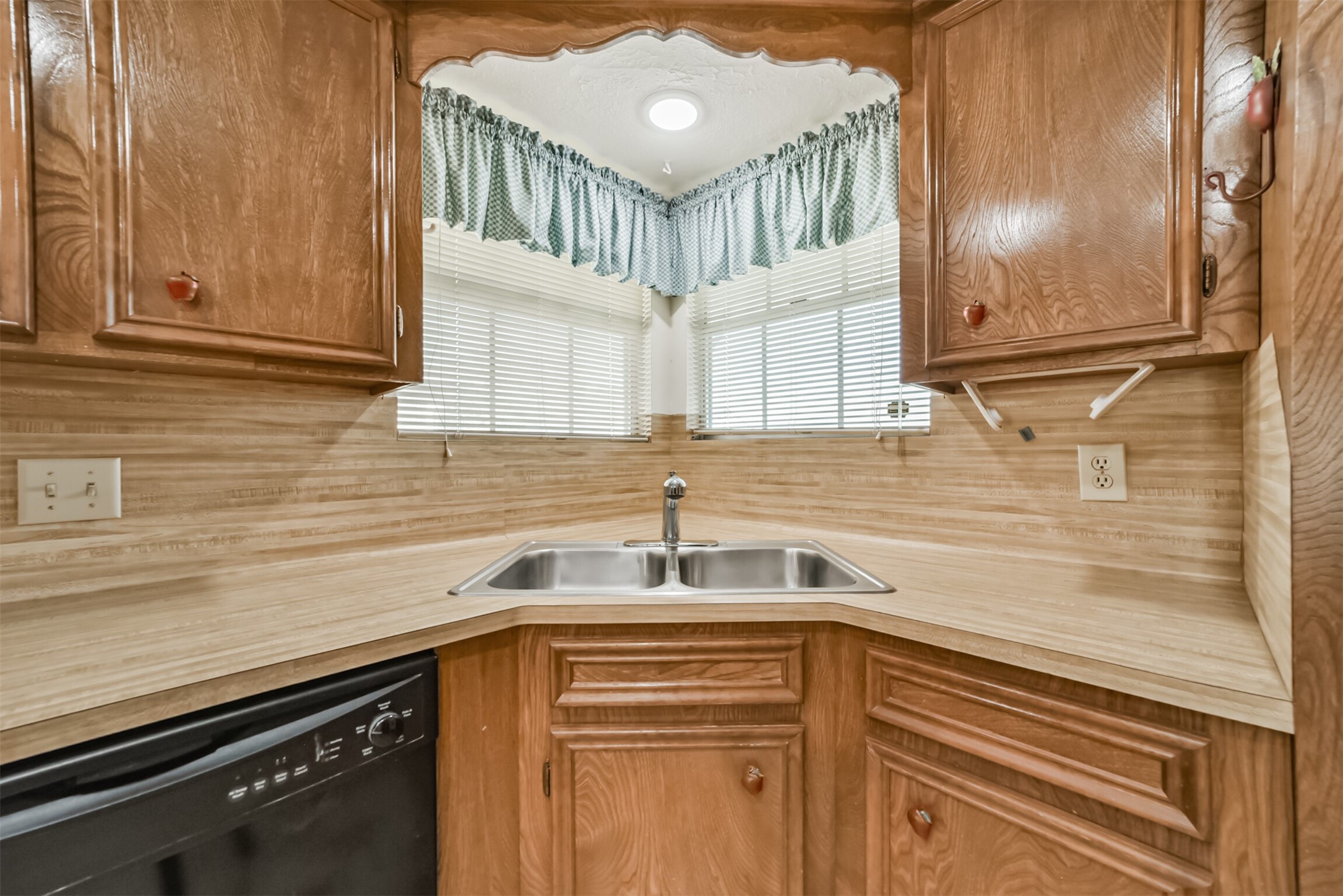 Enjoy a bright, cheerful kitchen with this oversized window above the sink, filling the space with natural light while offering a lovely view of the front yard and street beyond.
