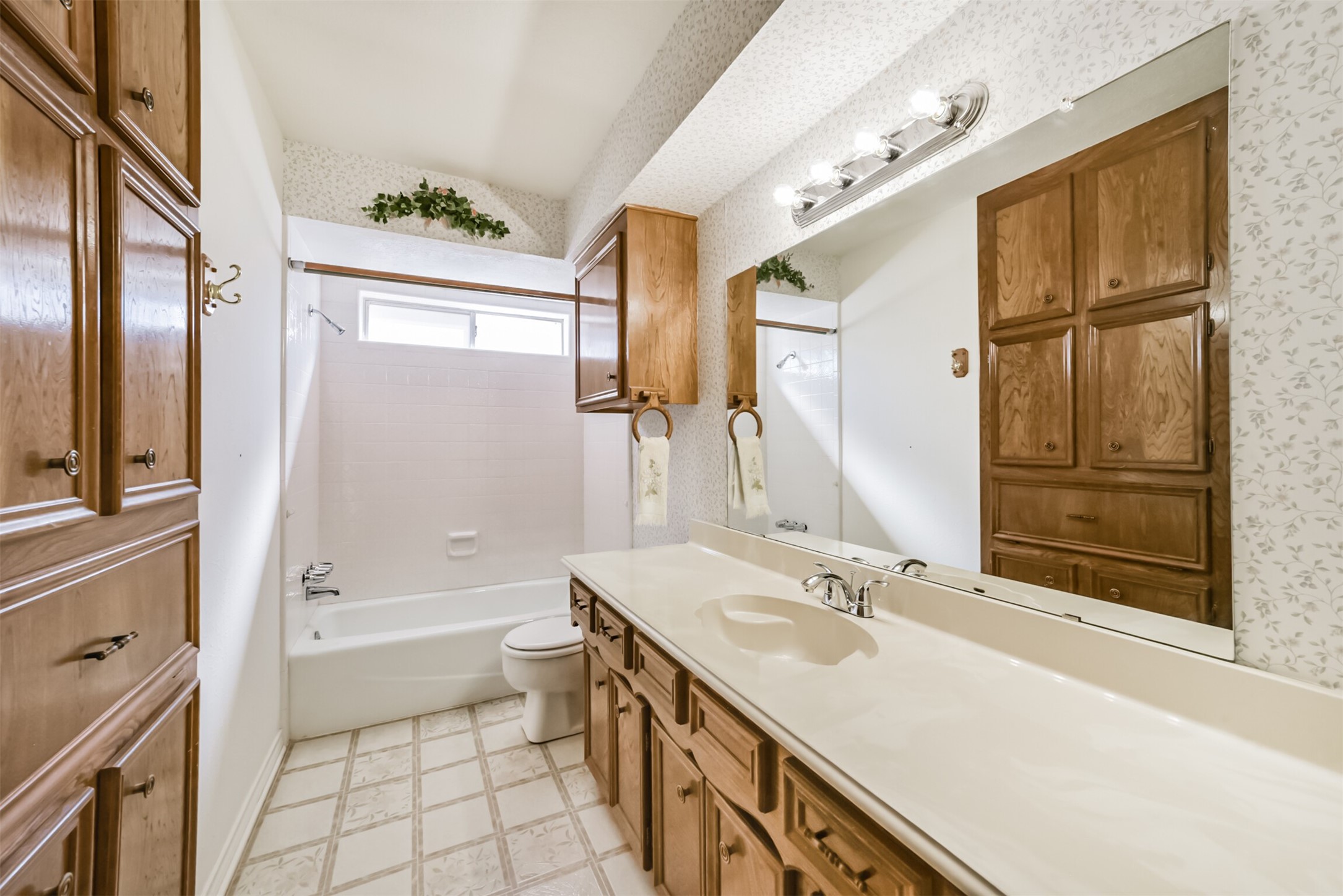 The second bathroom is spotless and offers lots of storage space, a tub/shower combo, and new lighting.