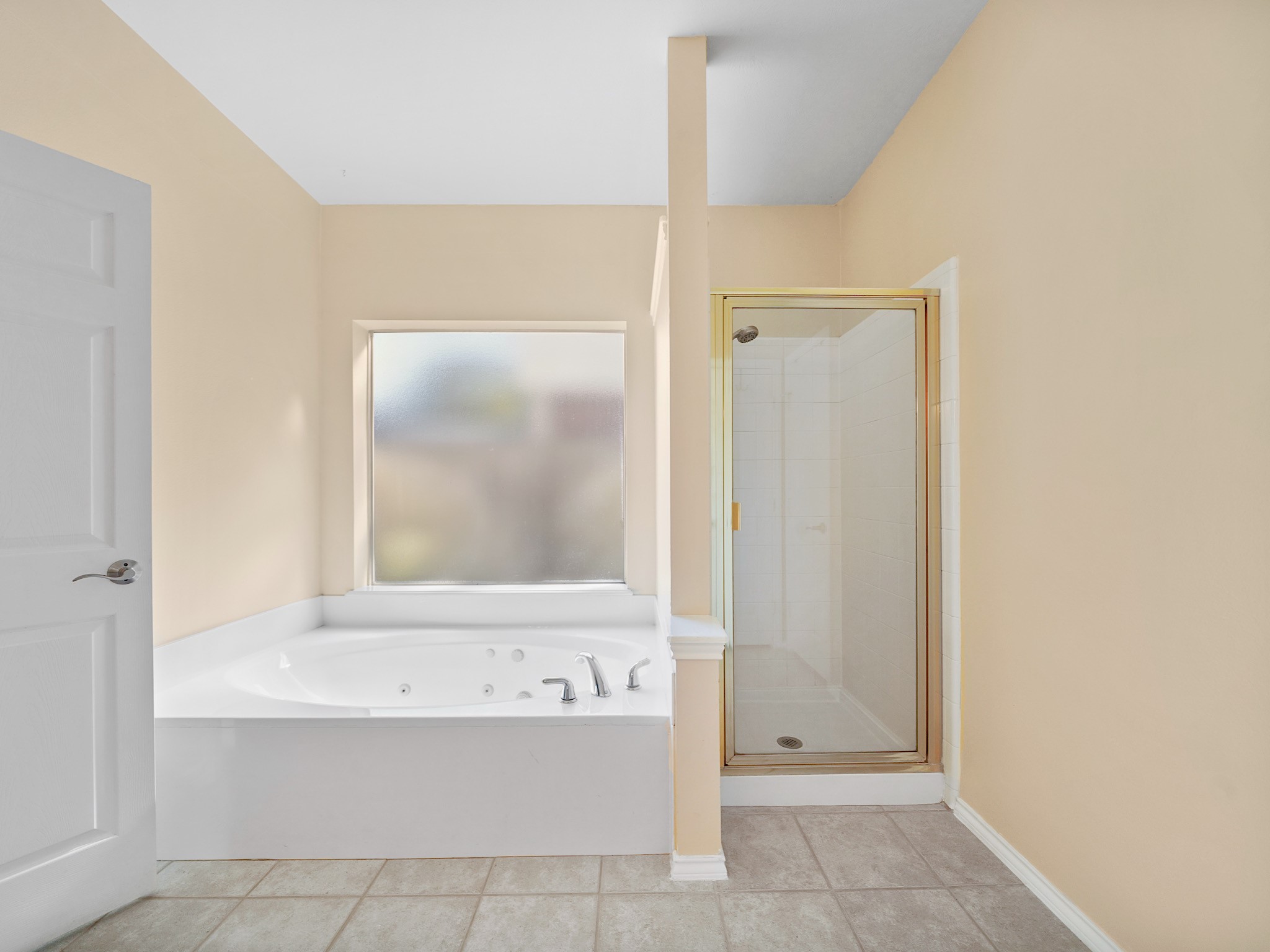 Let the day drift away in the jetted tub, tucked beneath a window for a peaceful setting. A separate shower adds convenience to the primary bath.
