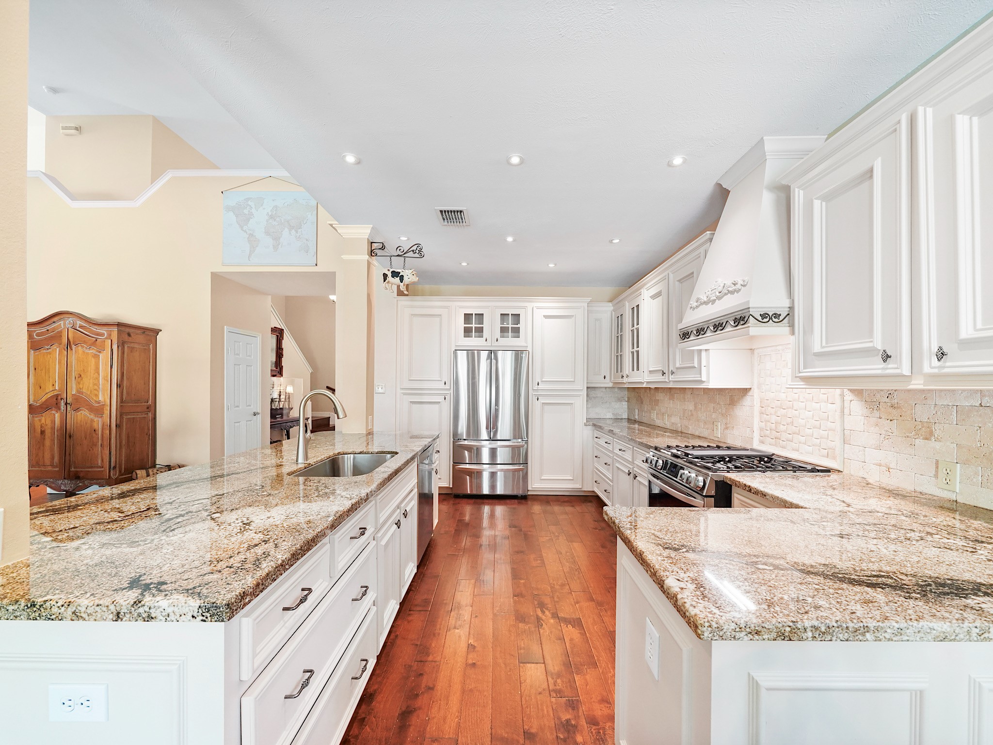 The kitchen pairs light cabinetry with granite countertops and warm wood flooring for a bright, welcoming feel. Generous counter space and storage make it easy to prepare everything from a quick breakfast to a holiday meal.