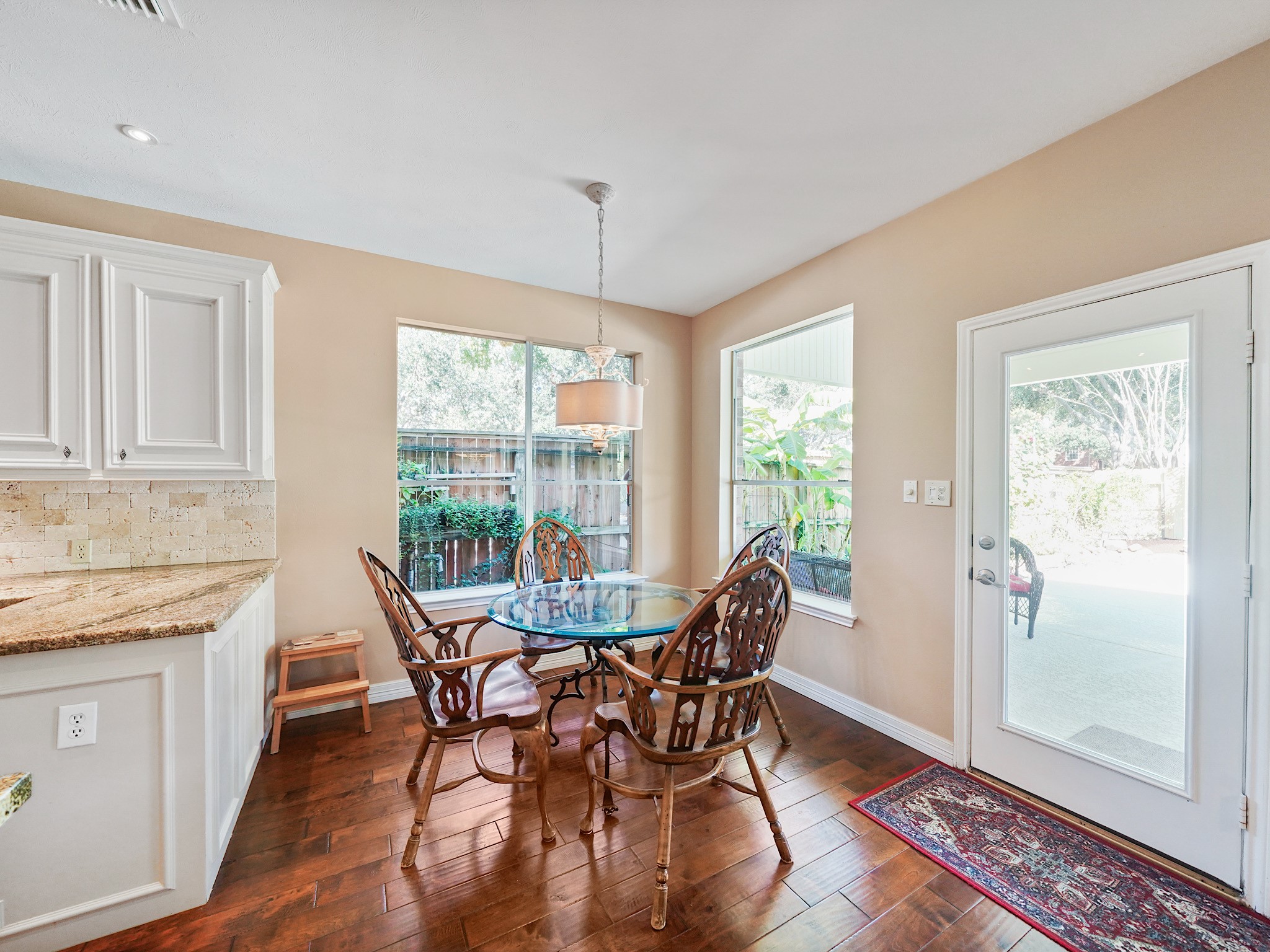 Surrounded by windows, the breakfast room is a cheerful spot to begin the morning. A nearby door leads toward the backyard, making it easy to carry meals and conversation outside.