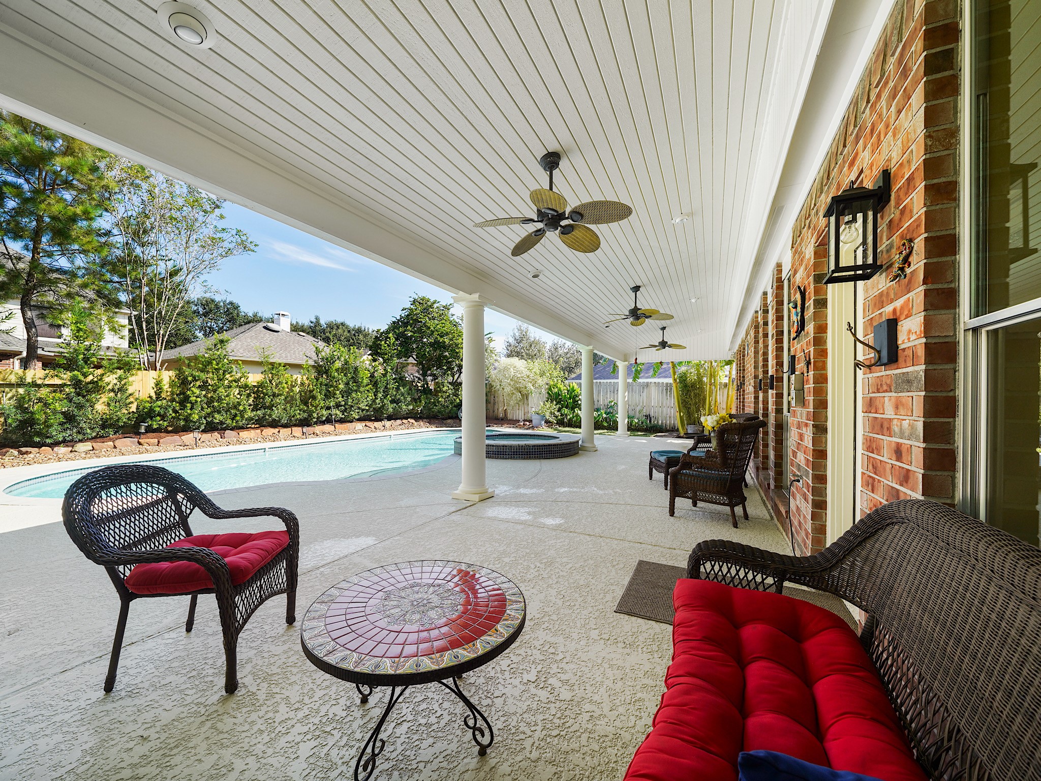 The huge covered patio invites you to slow down and enjoy the outdoors, whether youre sipping your morning coffee or visiting with friends after a swim. Ceiling fans help keep the shaded gathering space comfortable.