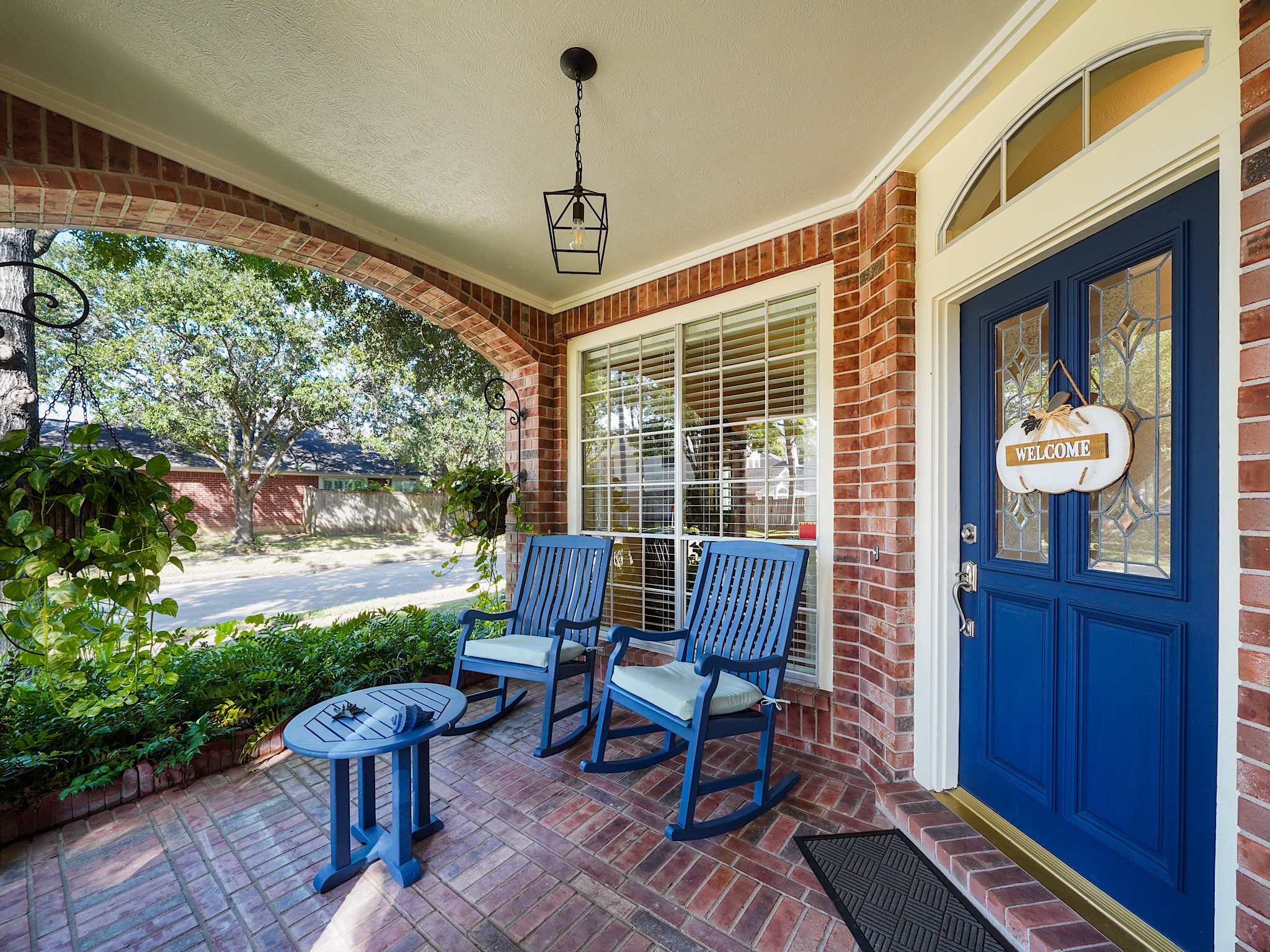 A welcoming front porch offers a charming place to pause and enjoy the neighborhood. The blue front door adds a cheerful touch and hints at the warmth waiting inside.